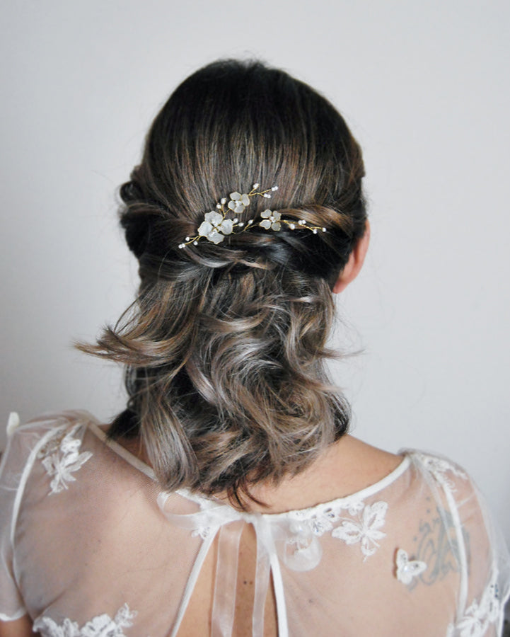 forcina di fiori bianchi e perline su semi raccolto da sposa