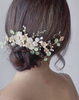 Pettinino elegante con fiori bianchi e accenti verdi, per uno stile country romantico.