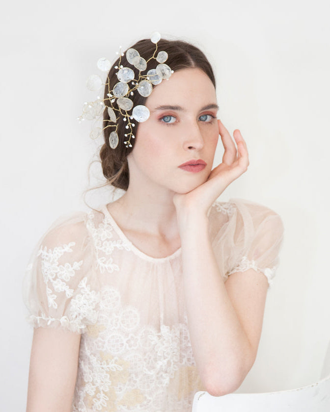 Fermaglio con dischi madreperlati per un effetto luminoso e naturale tra i capelli.