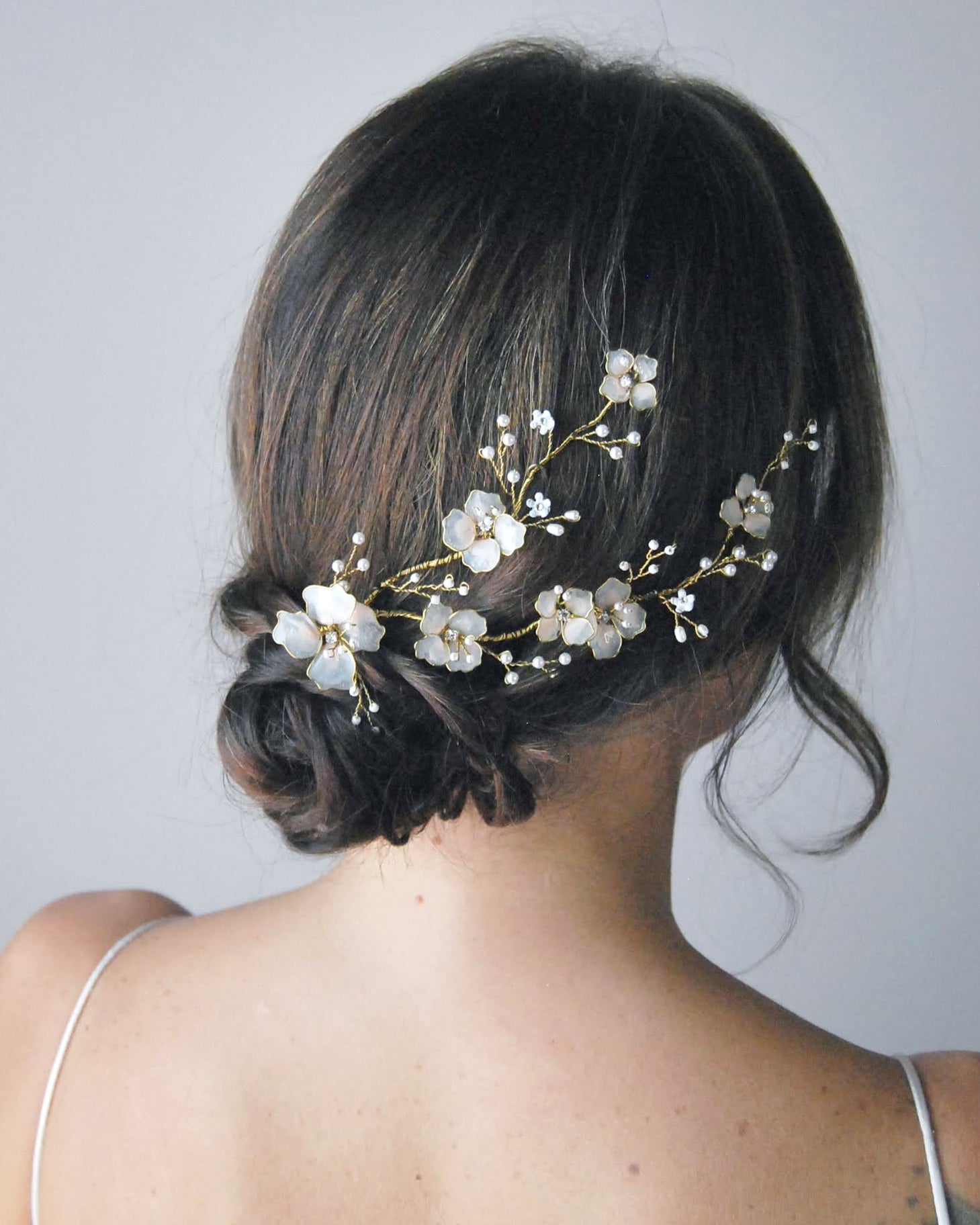 Fermaglio laterale artigianale con fiori rosa per un look da sposa romantico e raffinato.