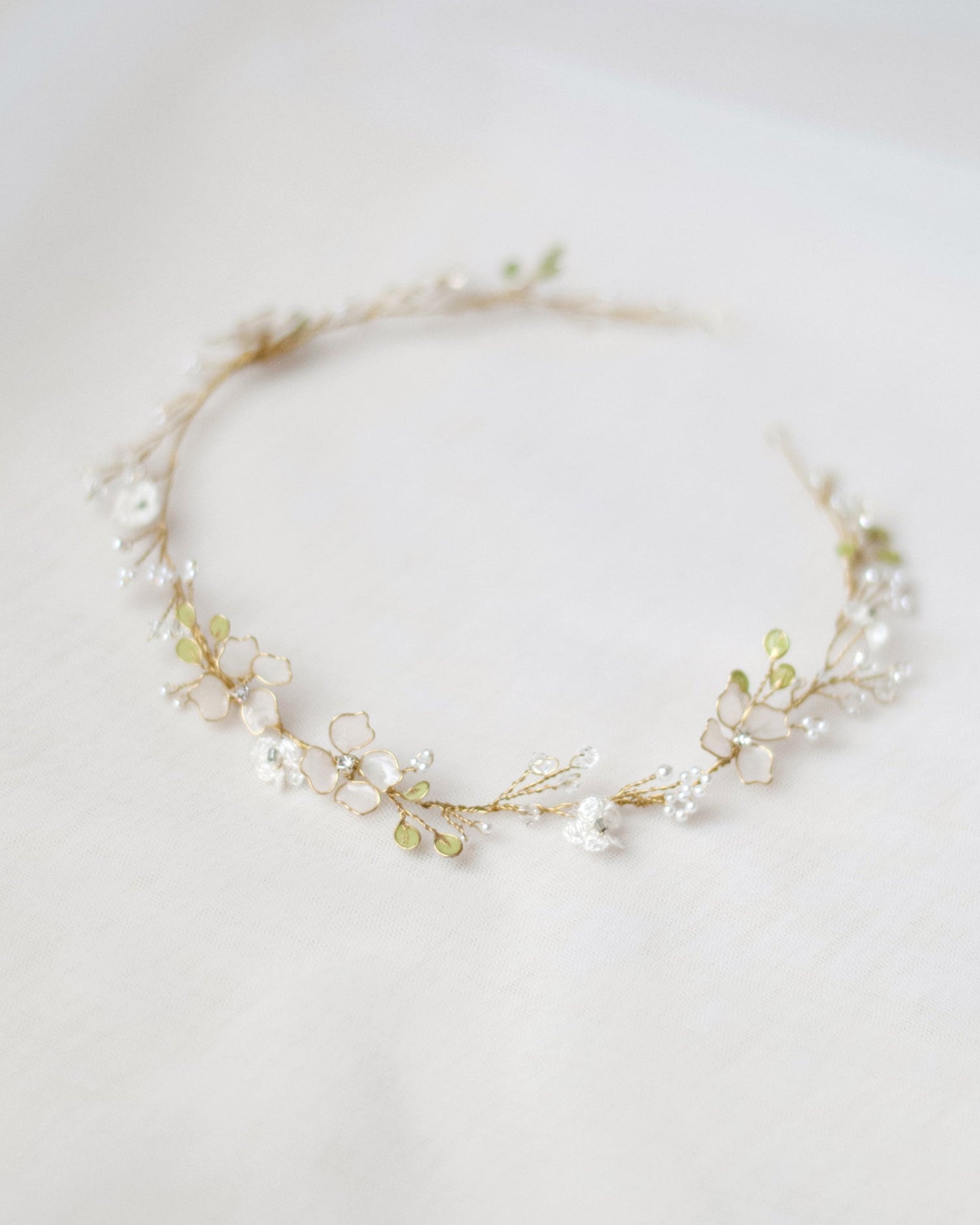 Elegante cerchietto con fiori di pizzo e foglie intrecciate, perfetto per la sposa.