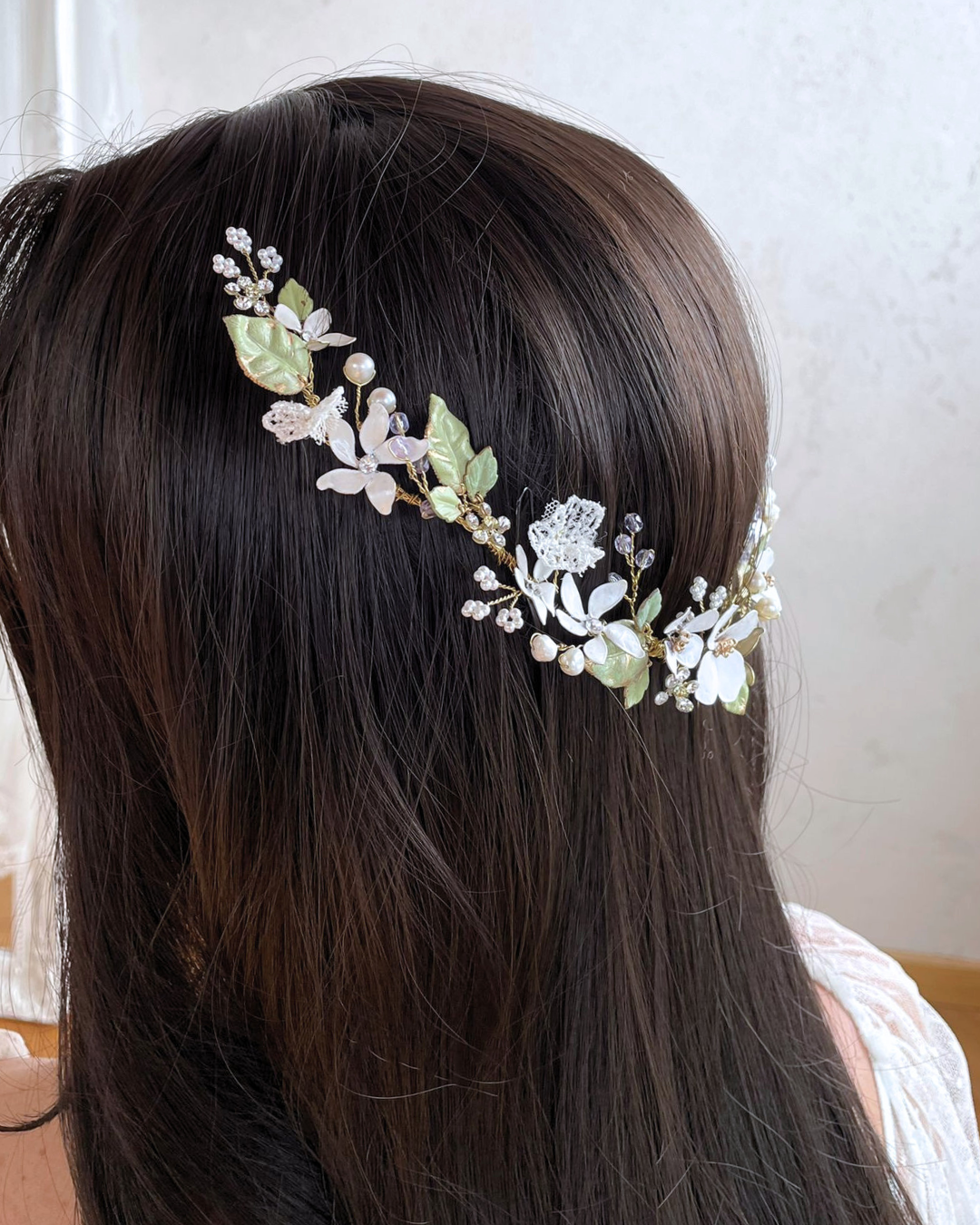 dettaglio dei fiori di zagare, foglie verdi e dei rametti lavanda che incorniciano i capelli sciolti con romanticismo