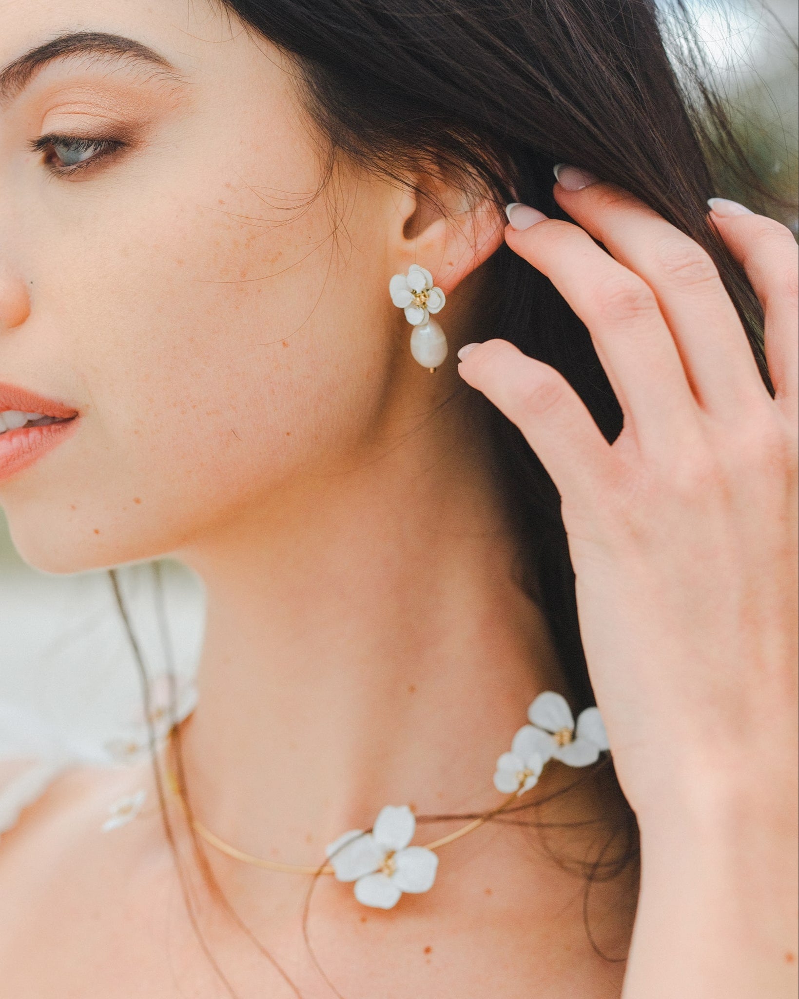 Set di gioielli con collana e orecchini, decorato con fiori bianchi, per un look elegante e raffinato da sposa.