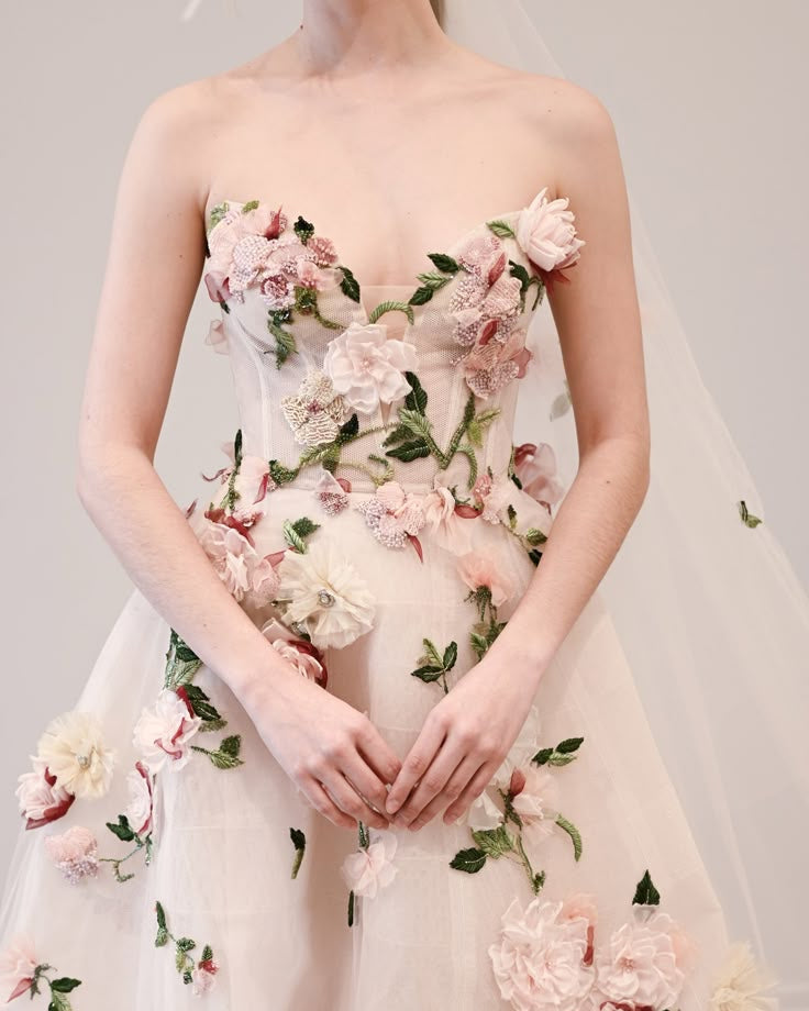 Abito da sposa rosa con fiori e foglie verdi.