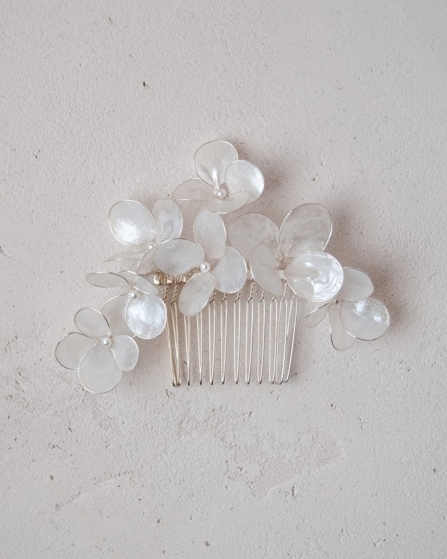 Elegante pettinino con fiori madreperlati, perfetto per un look nuziale sofisticato.