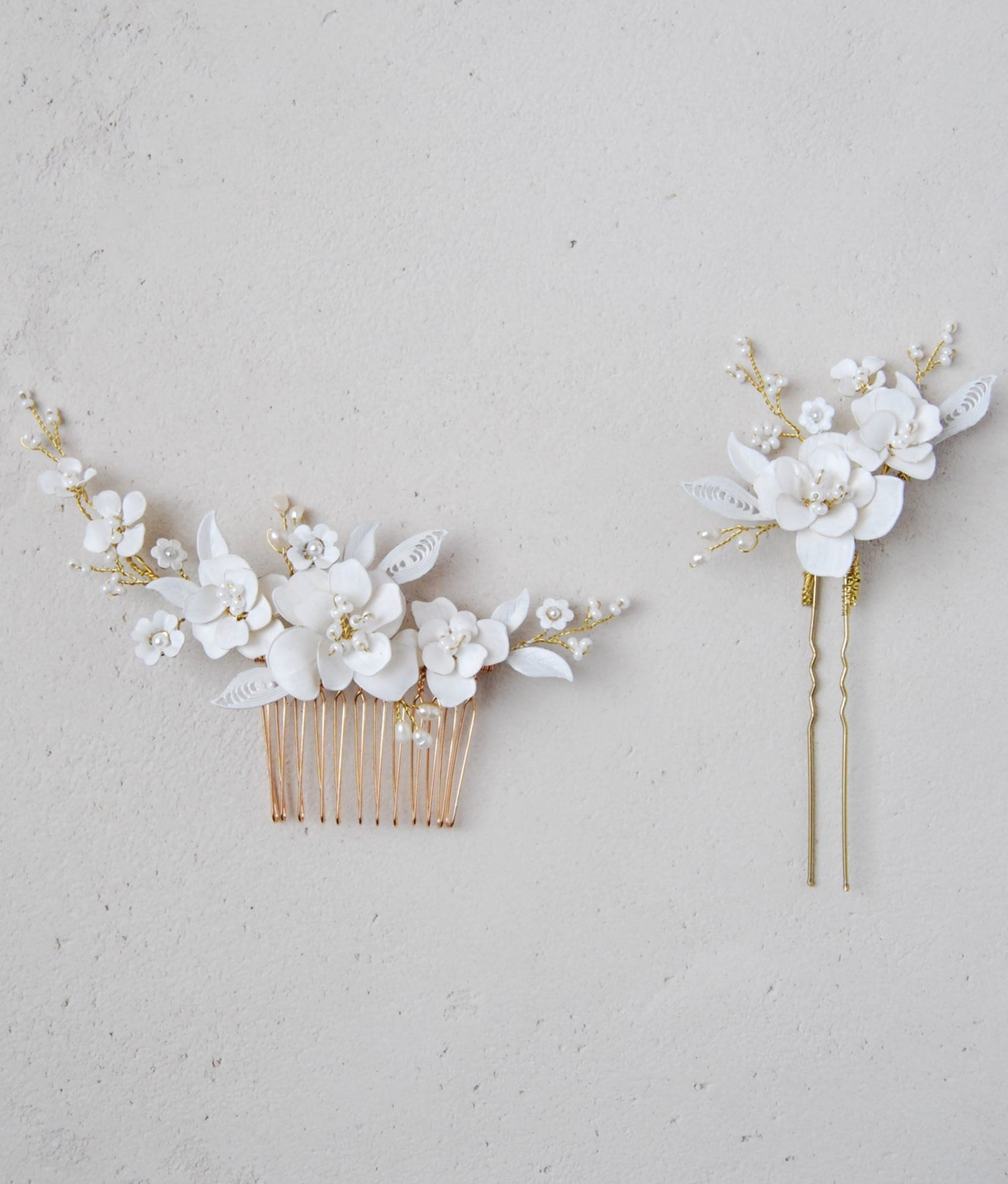 Fermagli per capelli decorati con fiori e foglie bianche, perfetti per matrimoni.
