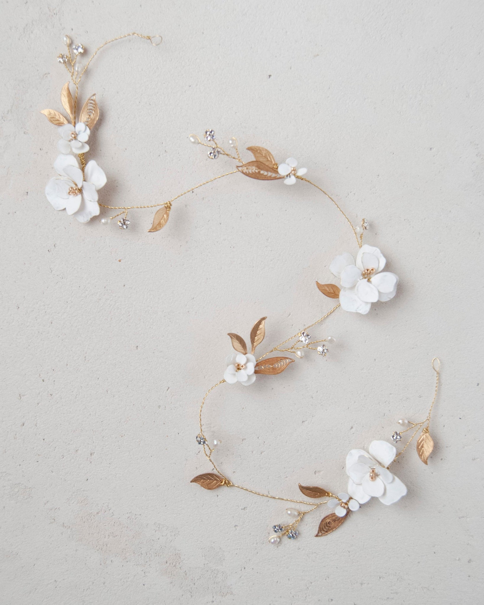 Accessorio capelli elegante: filo gioiello con fiori e foglie dorate, per spose moderne.