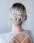 Accessorio per sposa alternativa con set di forcine floreali bianco seta dalla texture vellutata e design flessibile.