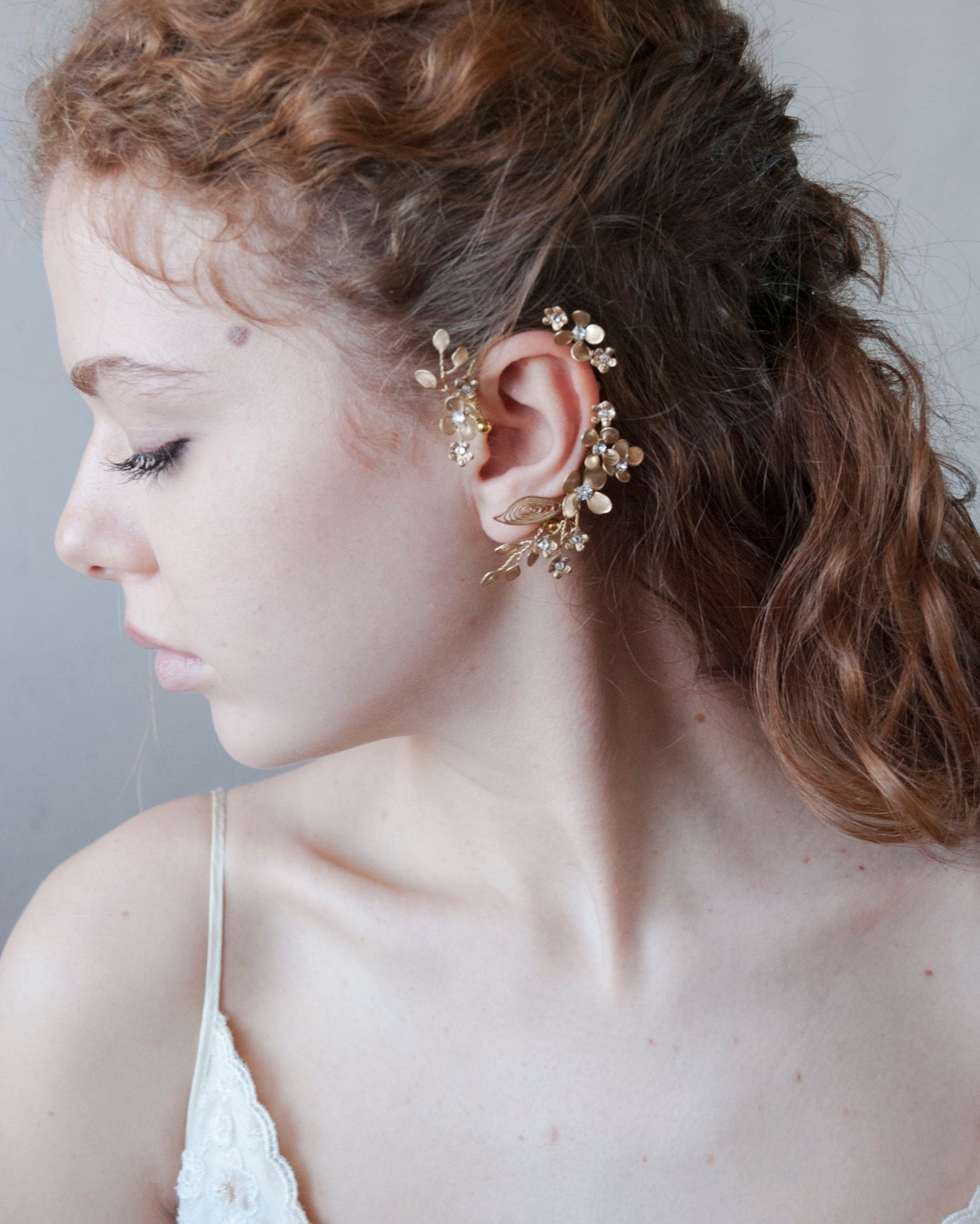 Accessorio orecchio: ear cuff dorato con design floreale delicato.