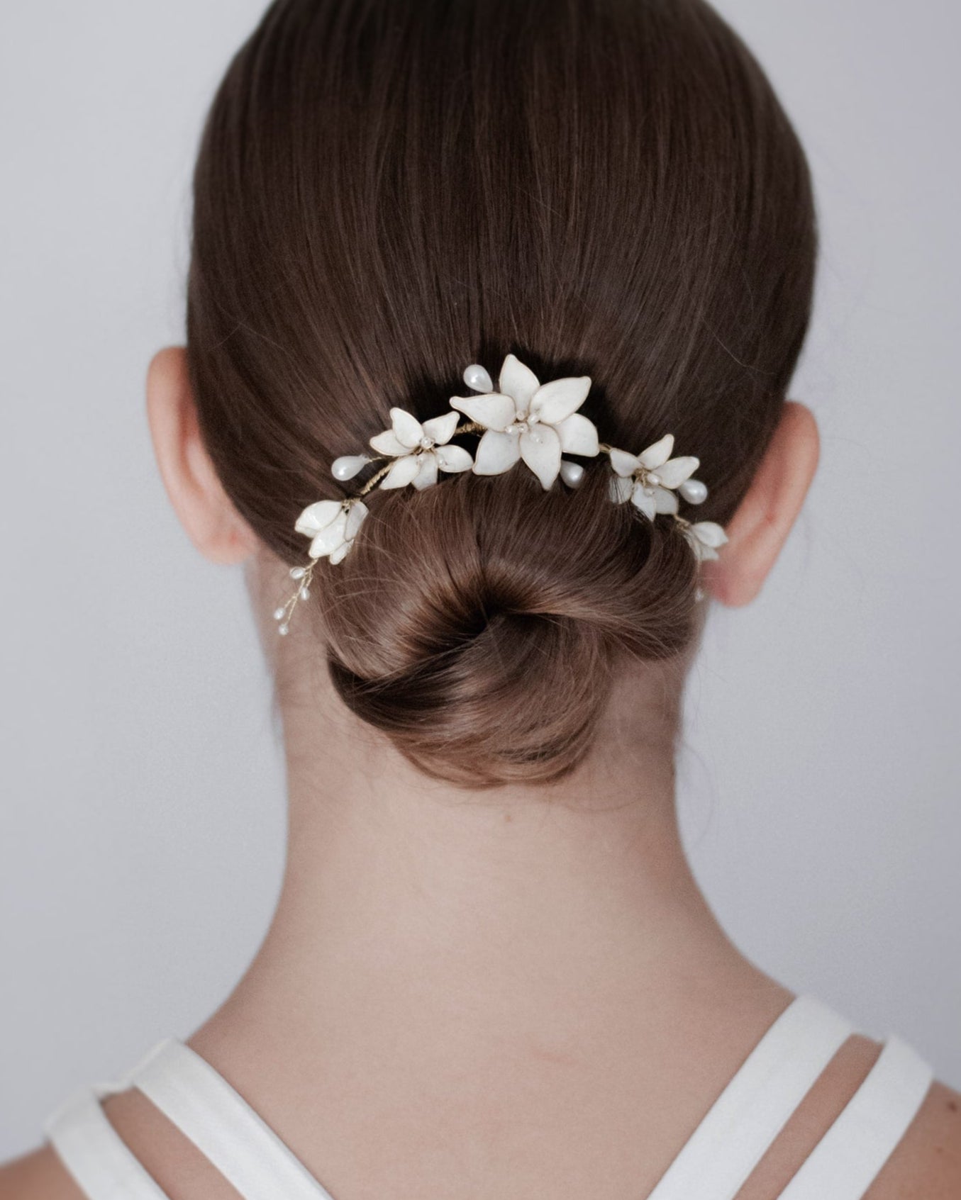 Fermaglio floreale con fiori bianchi tipo lilium, per un tocco di classe essenziale.