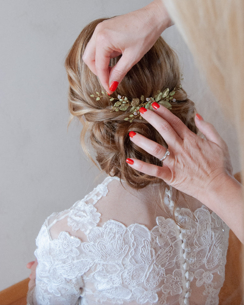 Sposa mentre viene acconciata da un parrucchiere, per un look elegante e curato.