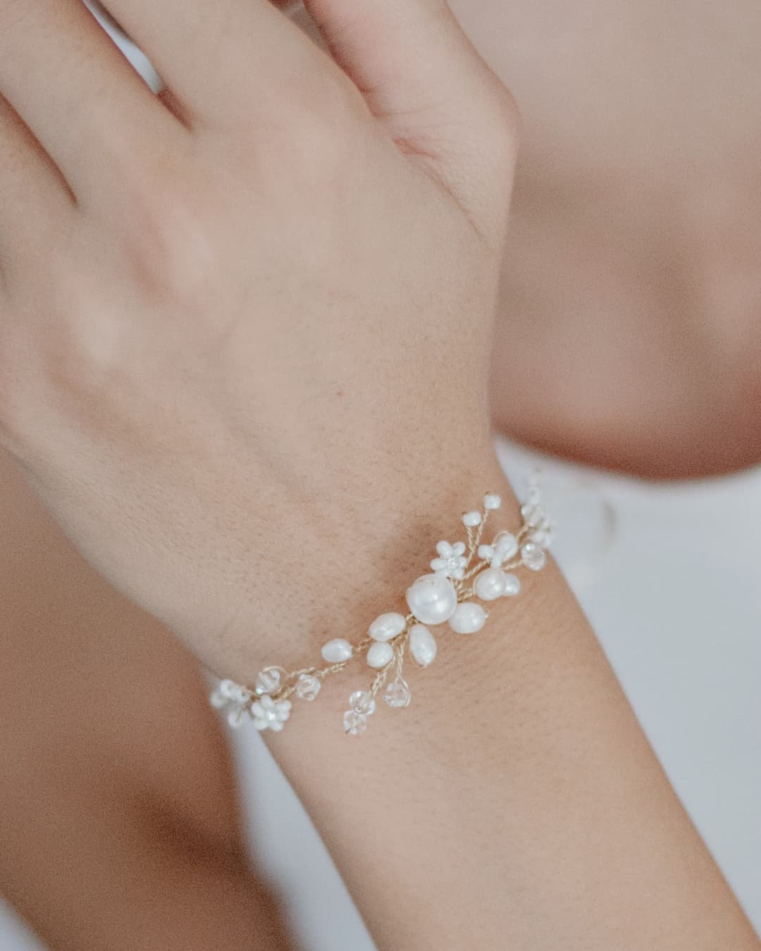 Bracciale gioiello dal design organico con chiusura in nastro di seta avorio per un look nuziale raffinato.