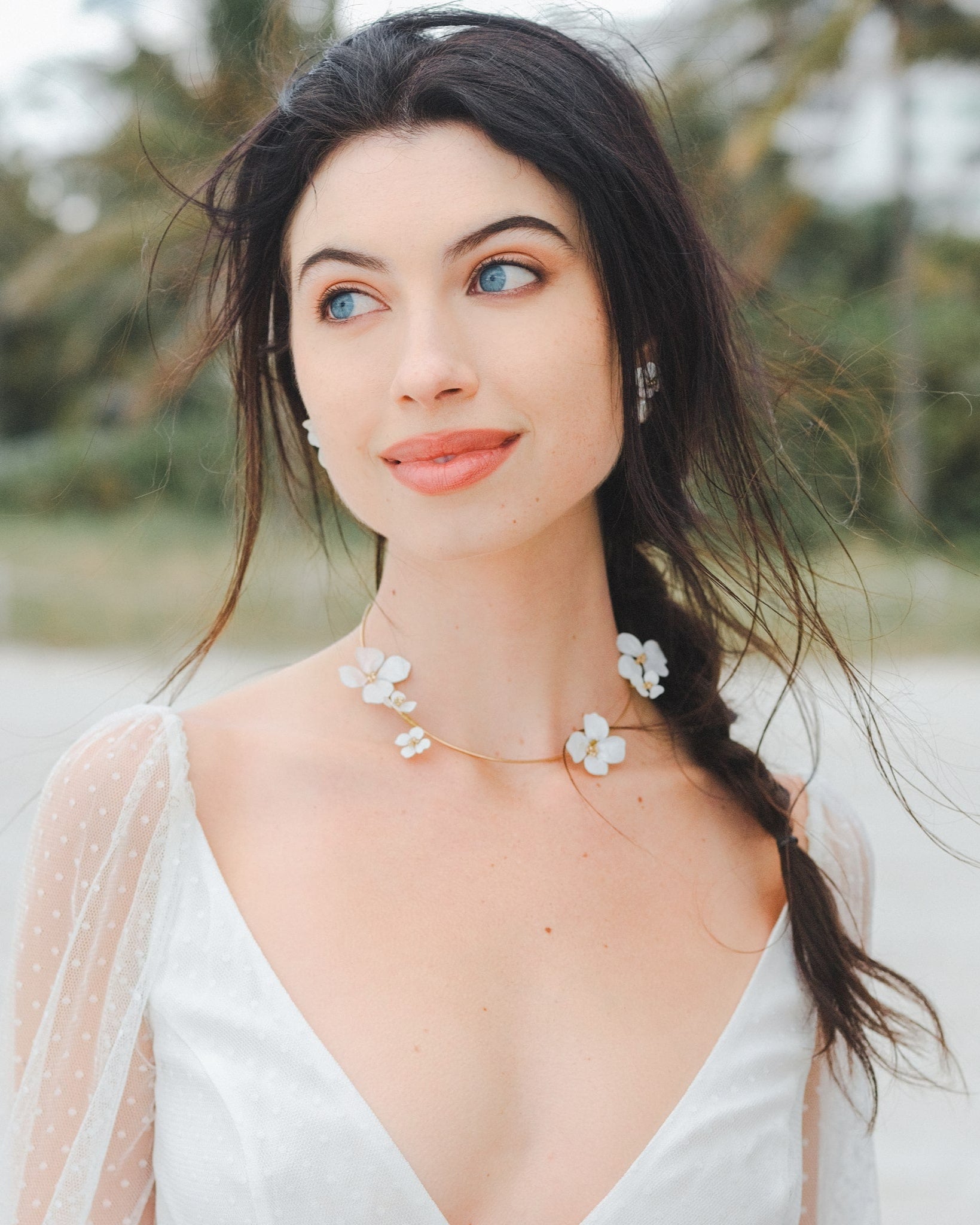 Collana con fiori bianchi, un accessorio floreale che dona un tocco romantico e delicato al tuo look da sposa.