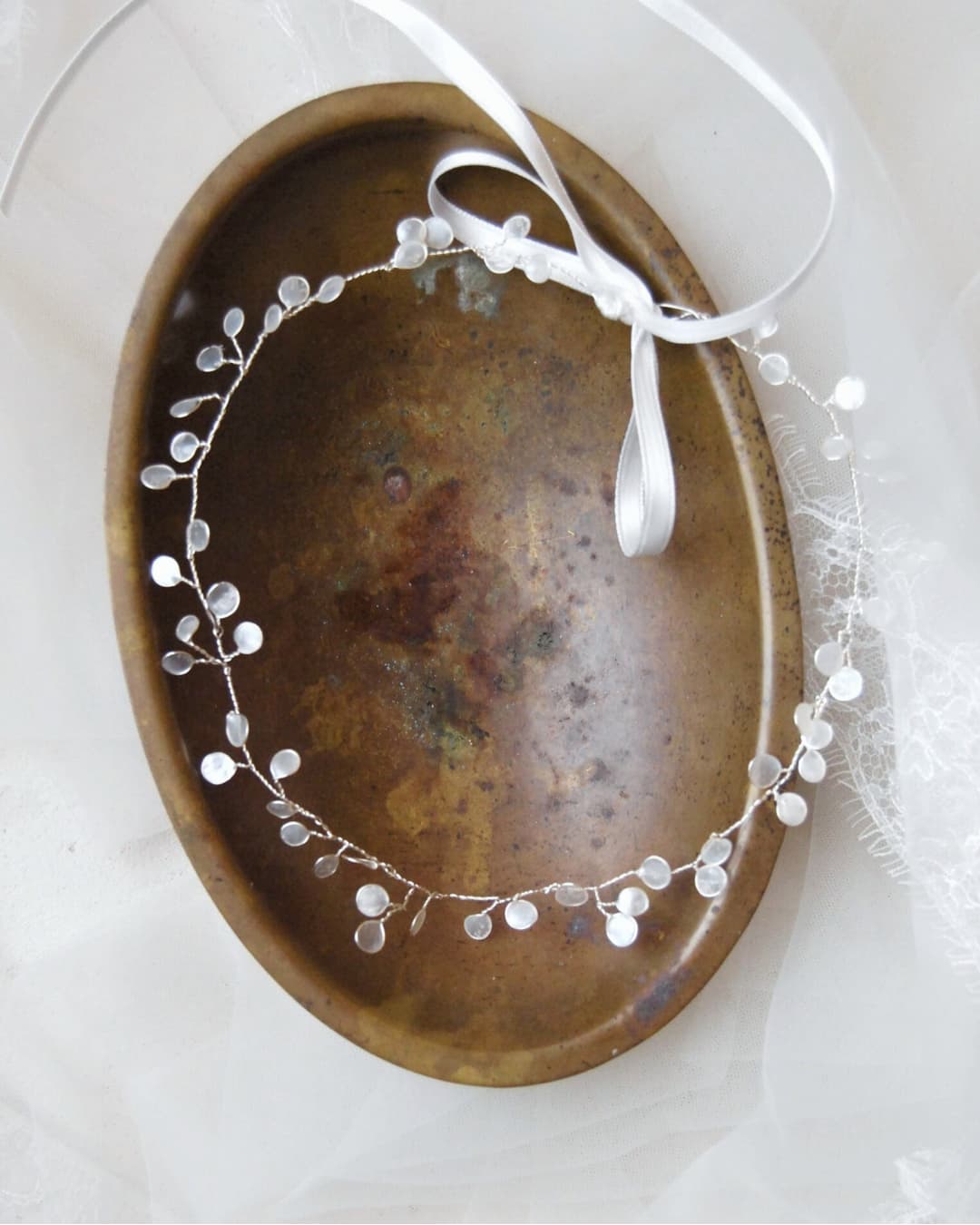 Girocollo gioiello dal design etereo con rami in finitura argento e petali luminosi ispirati ai riflessi lunari.