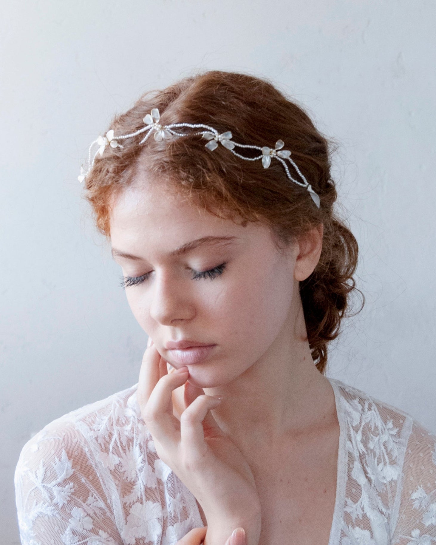 Coroncina elegante con perline e fiocchi madreperlati, perfetta per spose raffinate.