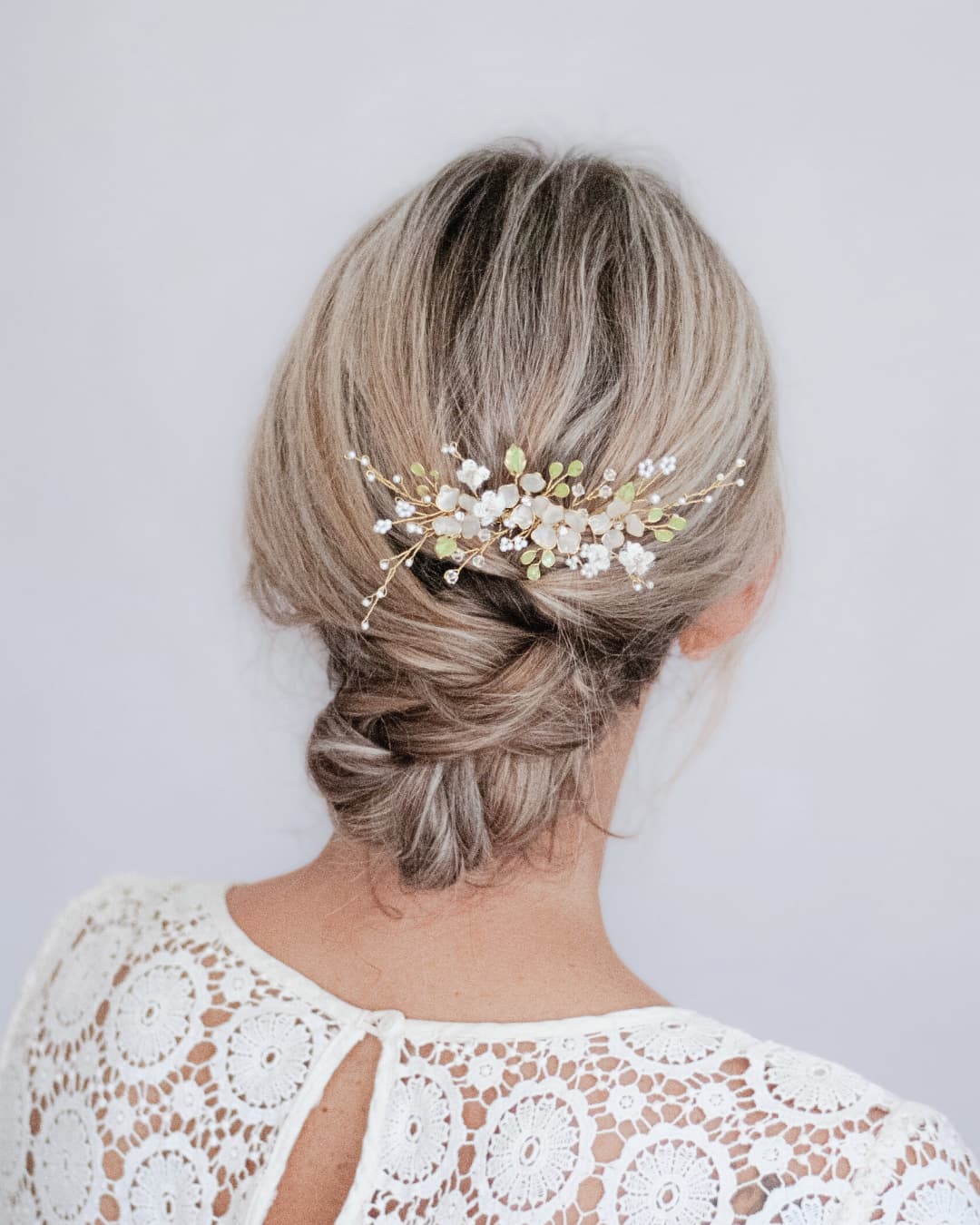 Primo piano del pizzo modellato e delle foglie dipinte a mano del pettinino Incanto.