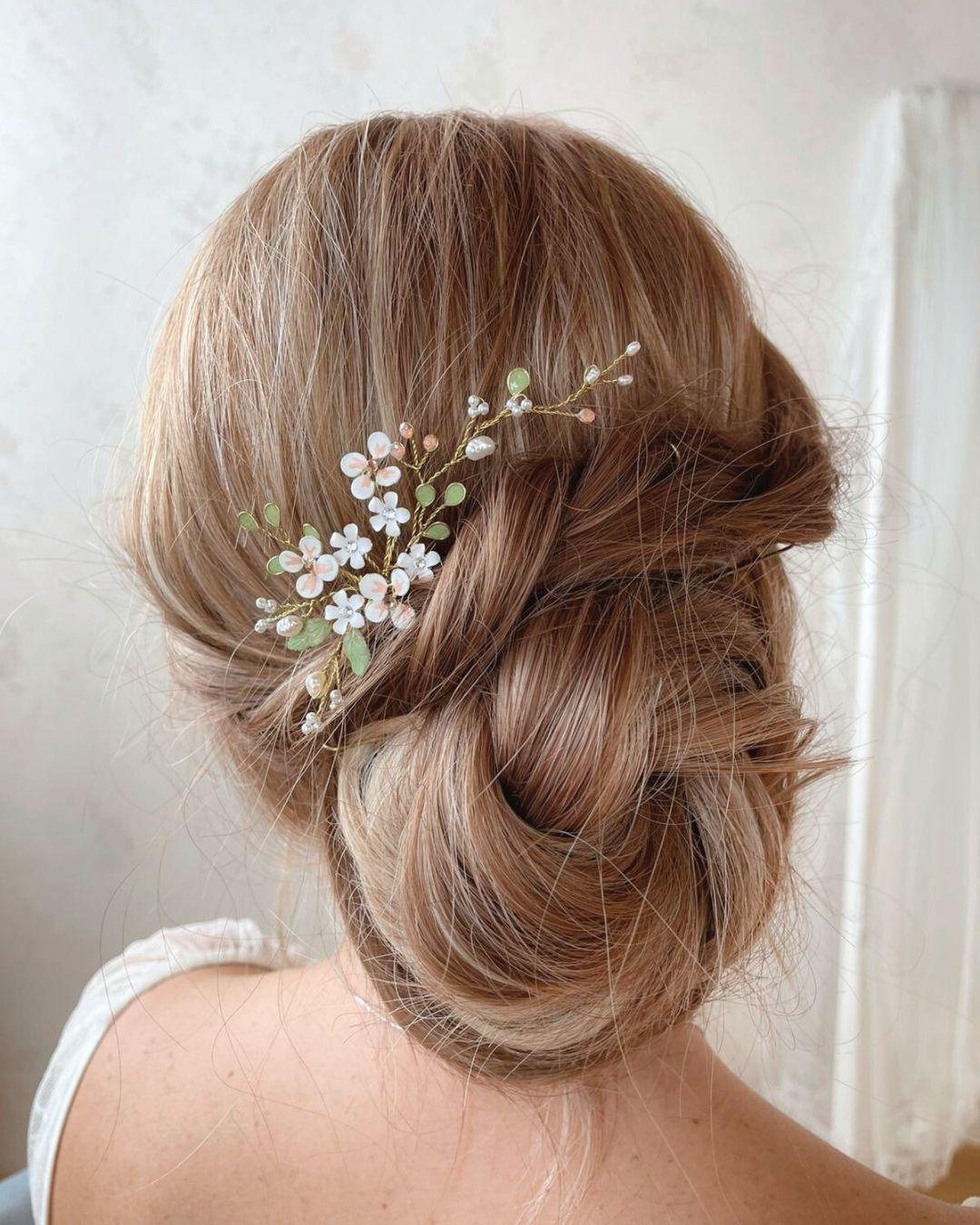 Primo piano dei fiori in porcellana fredda e delle perle di fiume intrecciate sulla forcina Ramilla.