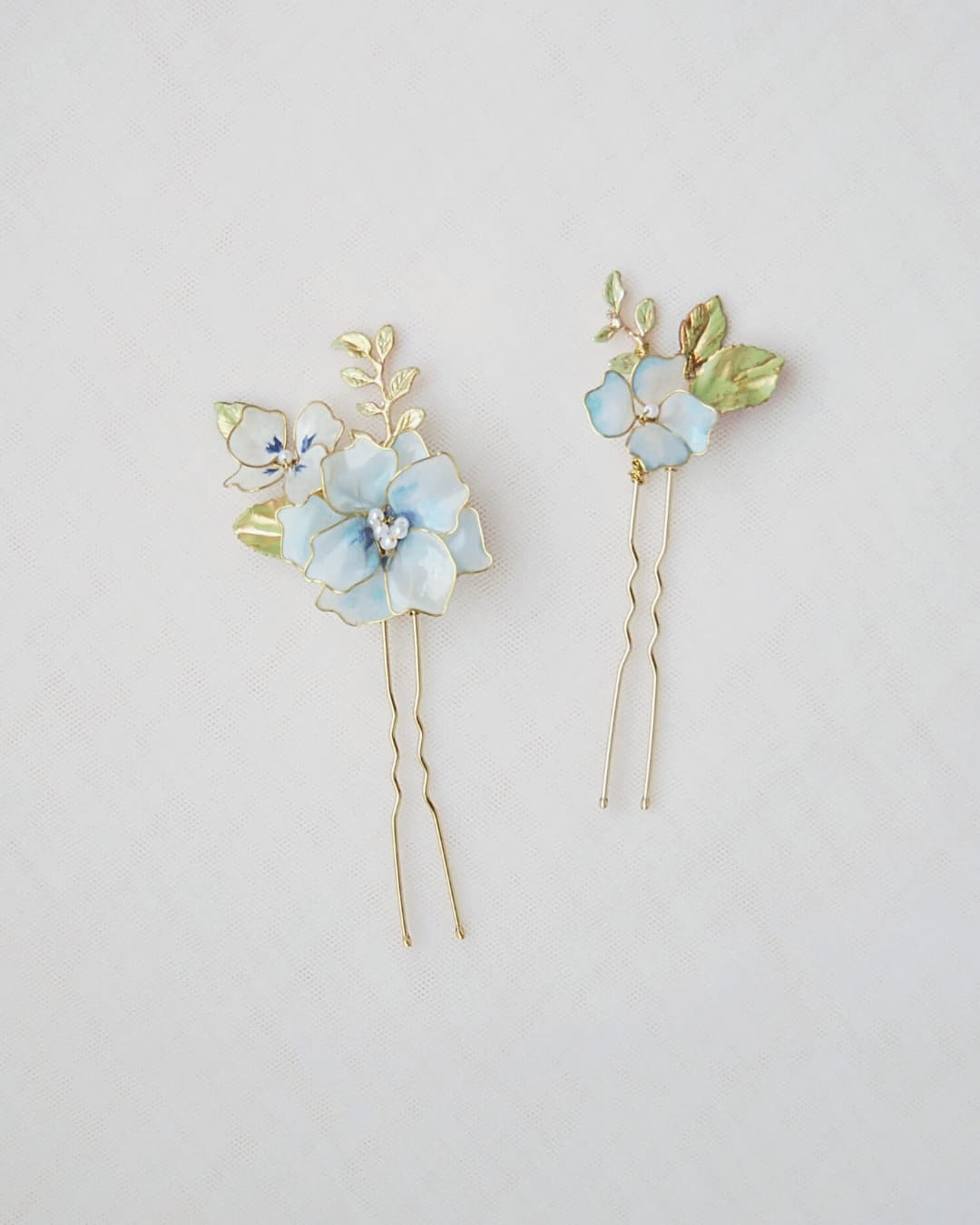 Particolare dei fiori azzurri semitrasparenti modellati a mano con finitura satinata Elibre.