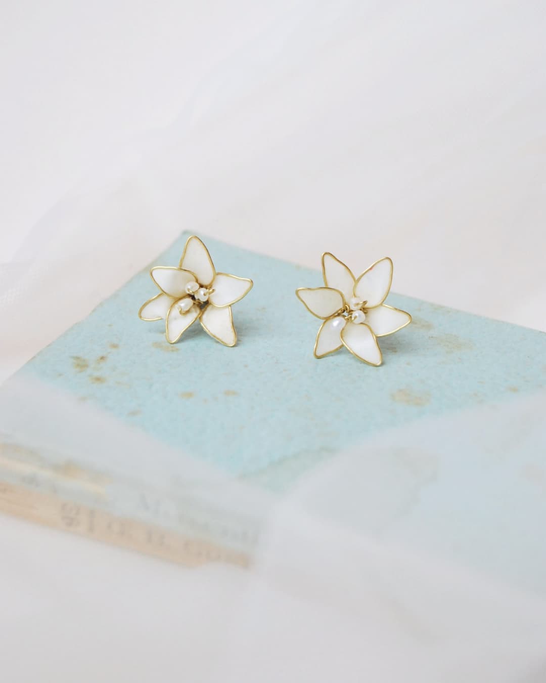 Primo piano di orecchini a forma di giglio bianco, accessorio nuziale raffinato