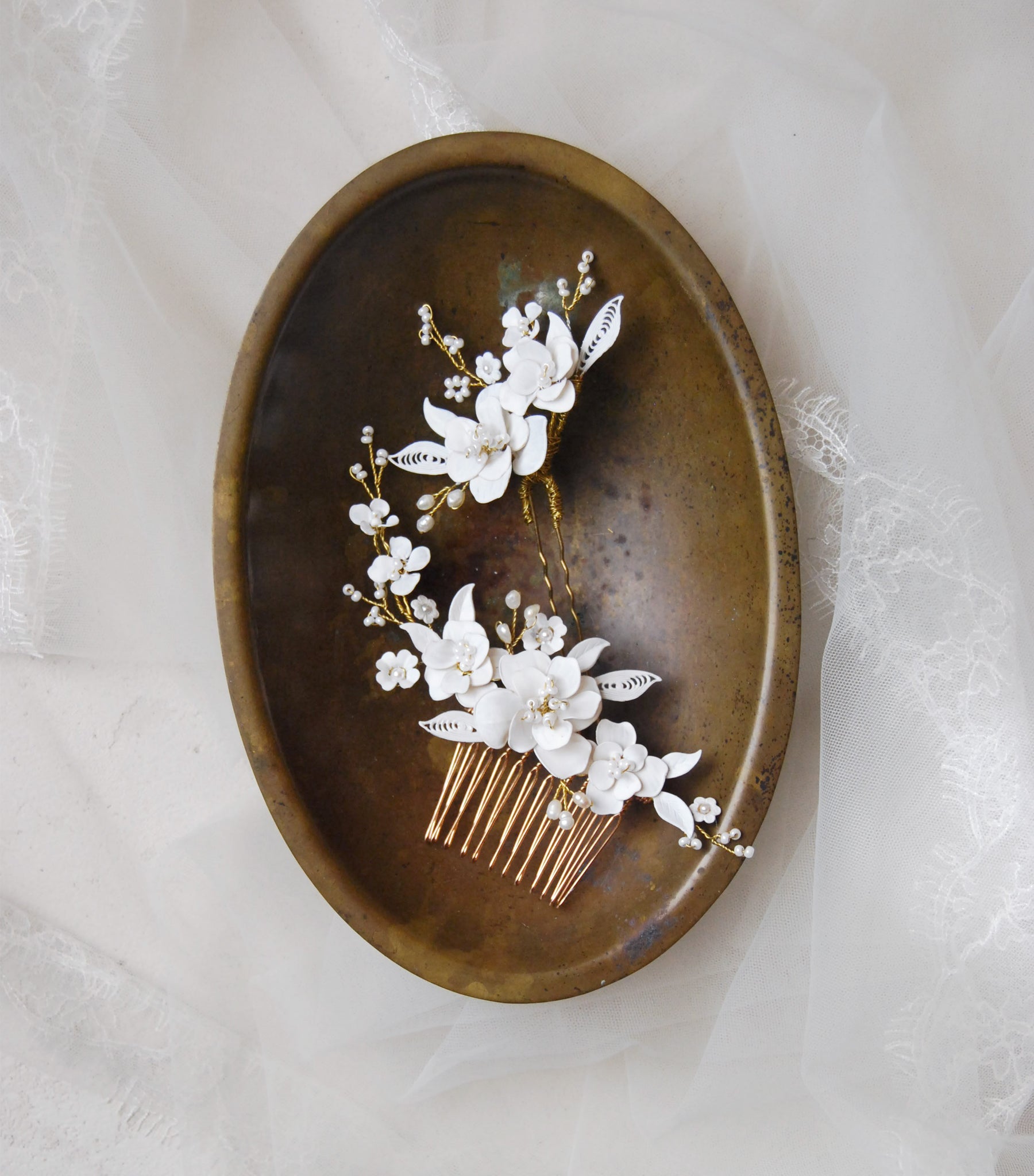 Fermagli da sposa artigianali con fiori bianchi e dettagli preziosi, ideali per valorizzare l’acconciatura.