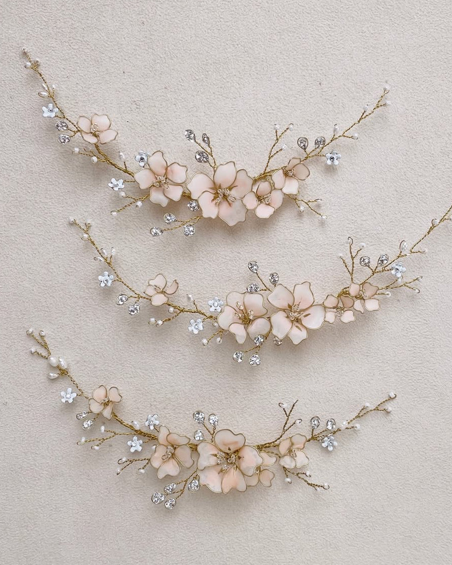Fermagli floreali con fiori di ciliegio rosa e cristalli, perfetti per acconciature da sposa romantiche e luminose.