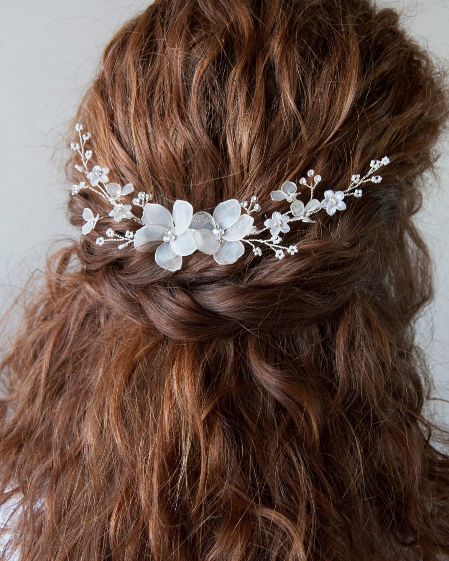 Fermaglio floreale con fiori satinati e cristalli scintillanti, per un look raffinato.