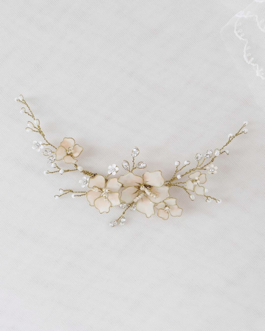 Fermaglio modellabile per sposa con fiori rosa cipria smaltati a mano e dettagli dorati.