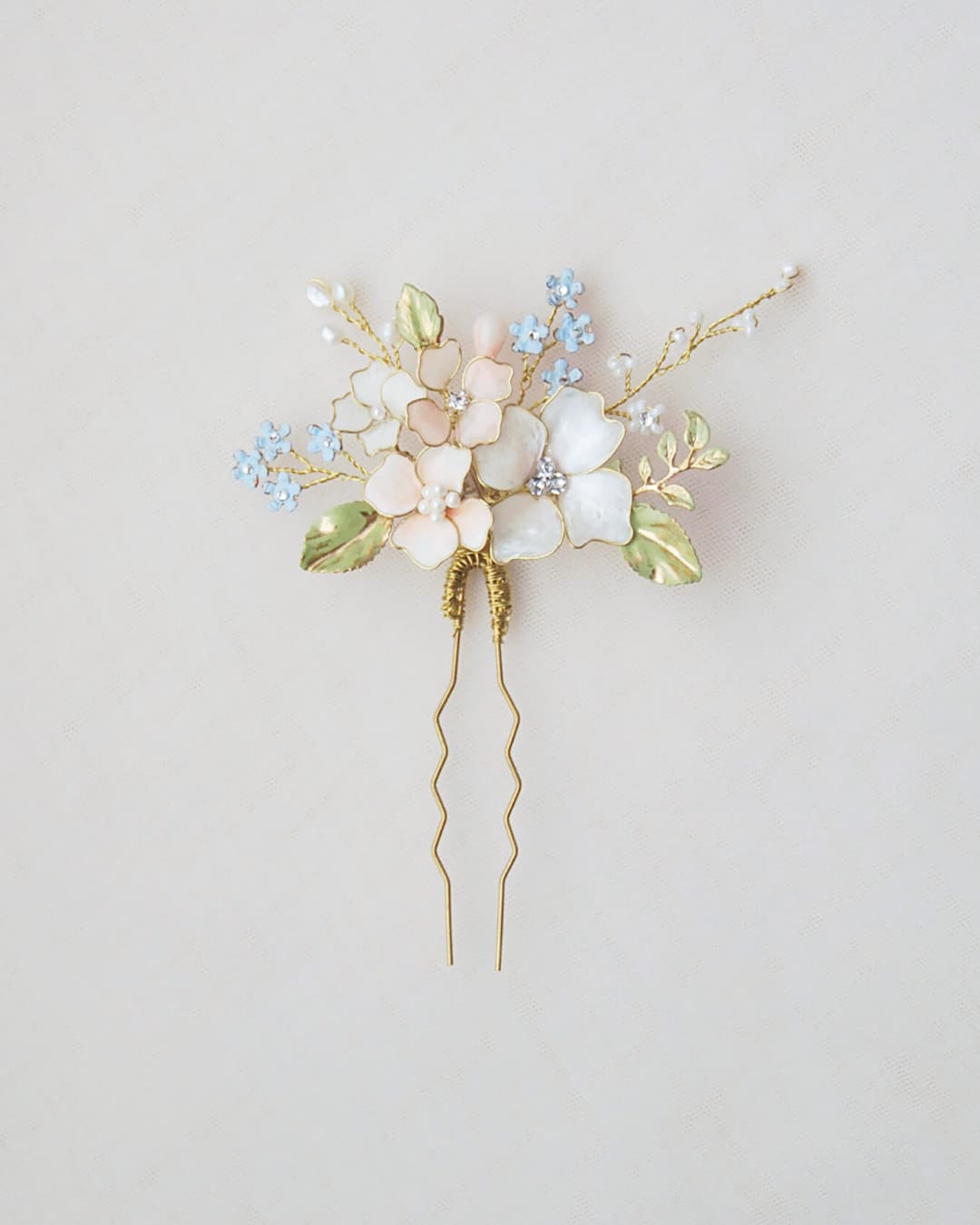 Forcina sposa floreale con fiori pastello azzurri e rosa cipria dipinti a mano con dettagli oro.