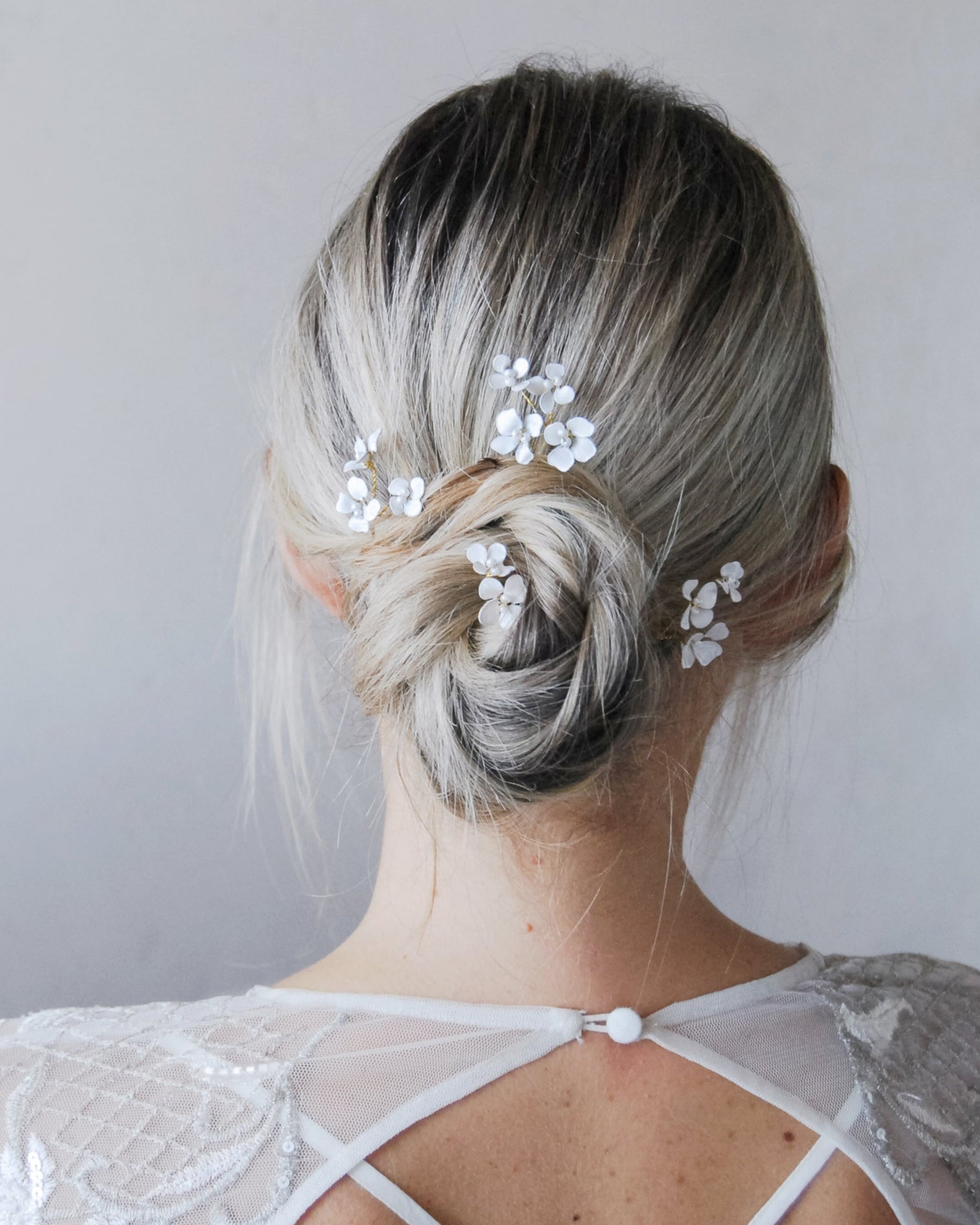 Set di forcine con fiorellini bianchi, perfetto per un’acconciatura da sposa elegante.