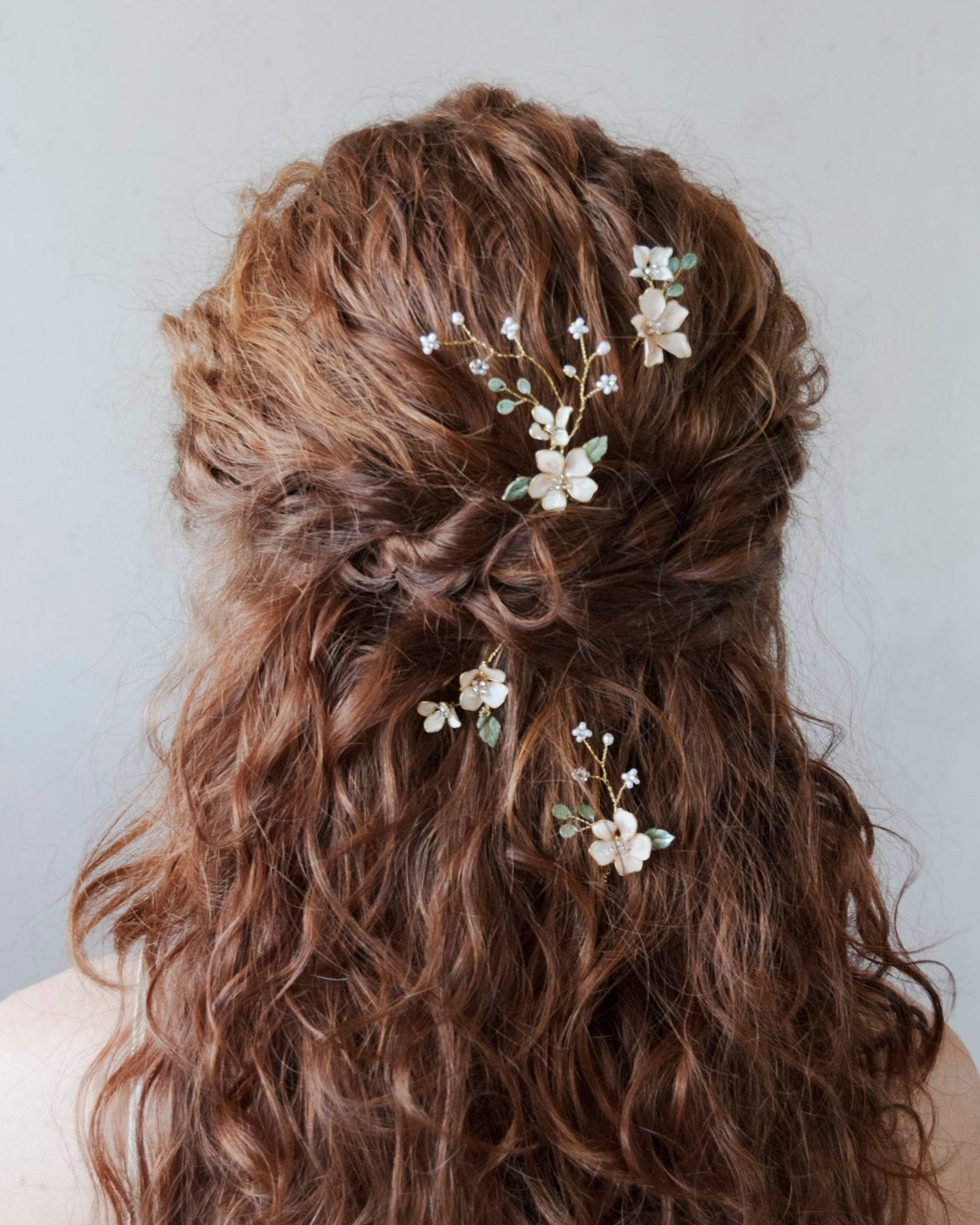 Forcine da sposa con fiori e foglie verdi rampicanti, perfette per un look bohemien e naturale.