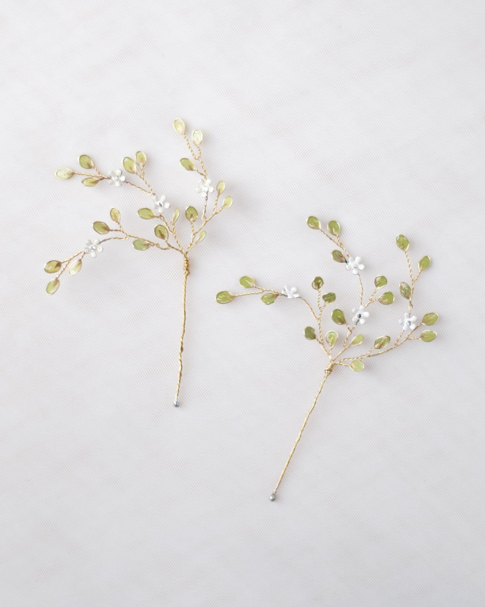 Forcine botaniche con tralci verdi e fiori bianchi, perfette per uno stile naturale.