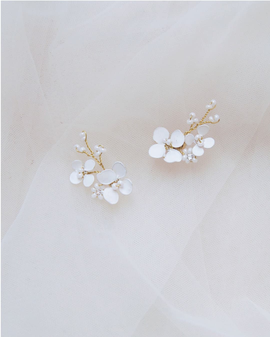 Dettaglio della lavorazione artigianale degli orecchini Biancospino Climber: fiori bianchi scultorei che risalgono il lobo.