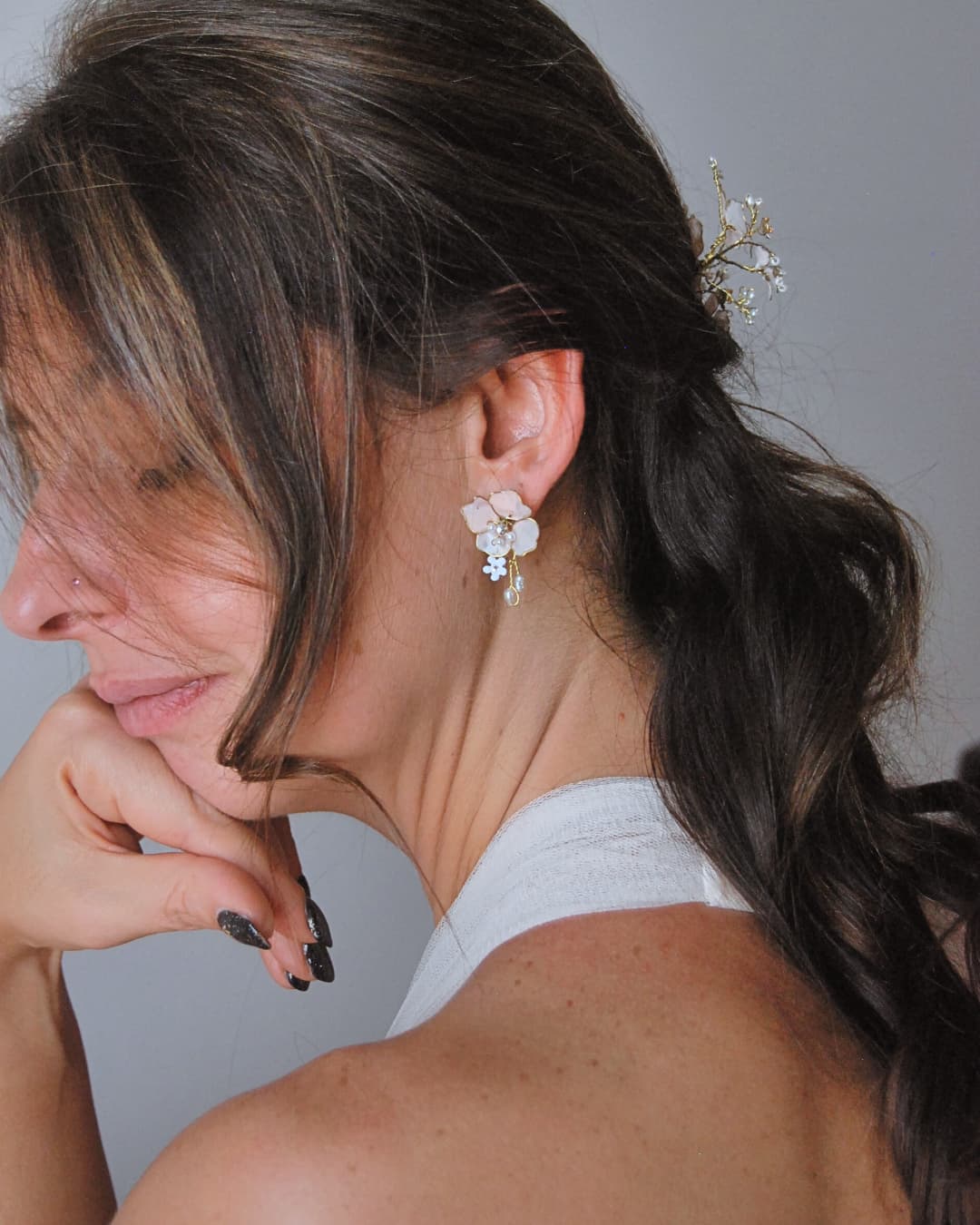 Dettaglio artigianale degli orecchini Sakura con rametti di perline e fiori dipinti, un accessorio distintivo d'élite.