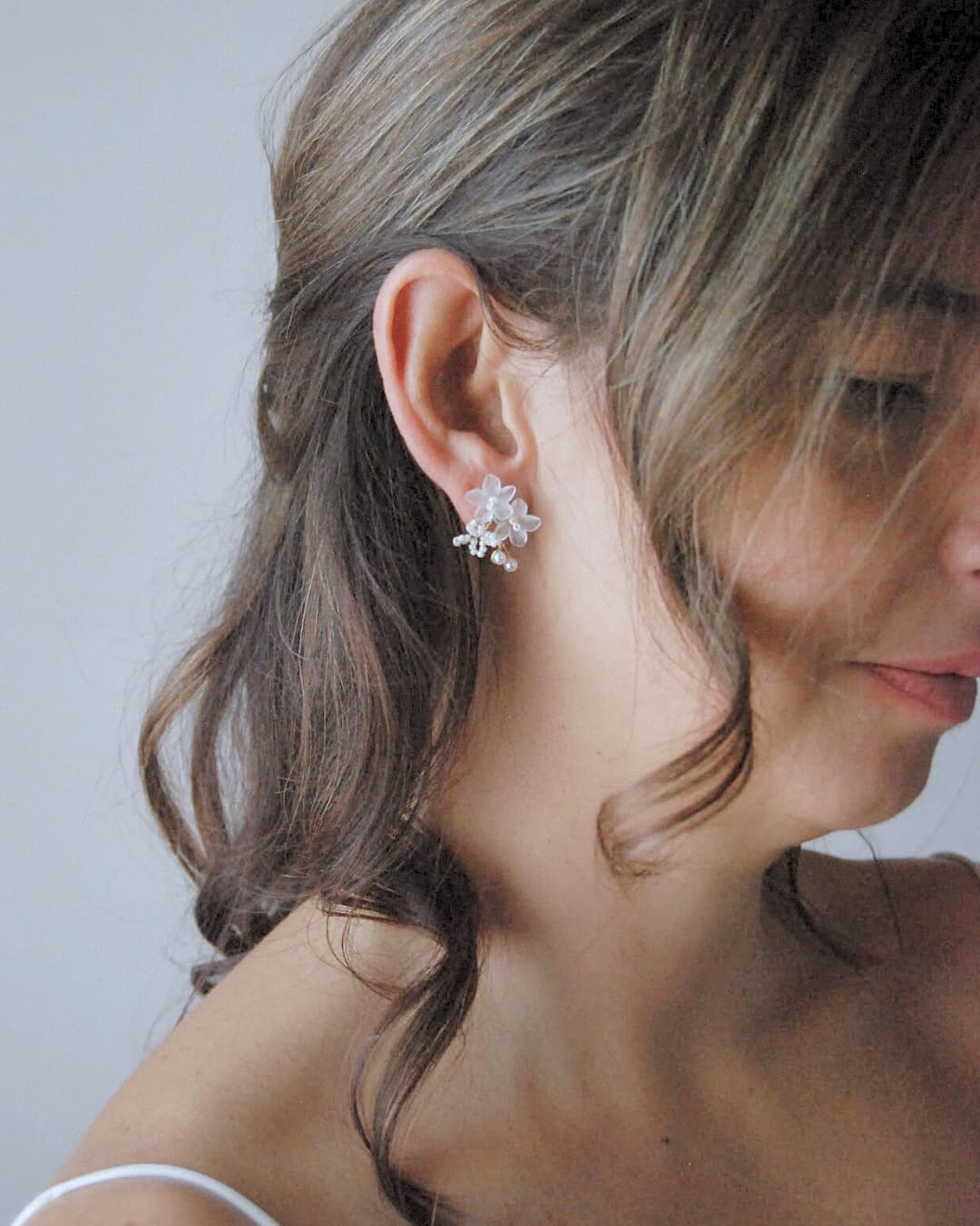 Orecchini artigianali Frangipane in finitura oro, realizzati a mano con fiori delicati e perle.