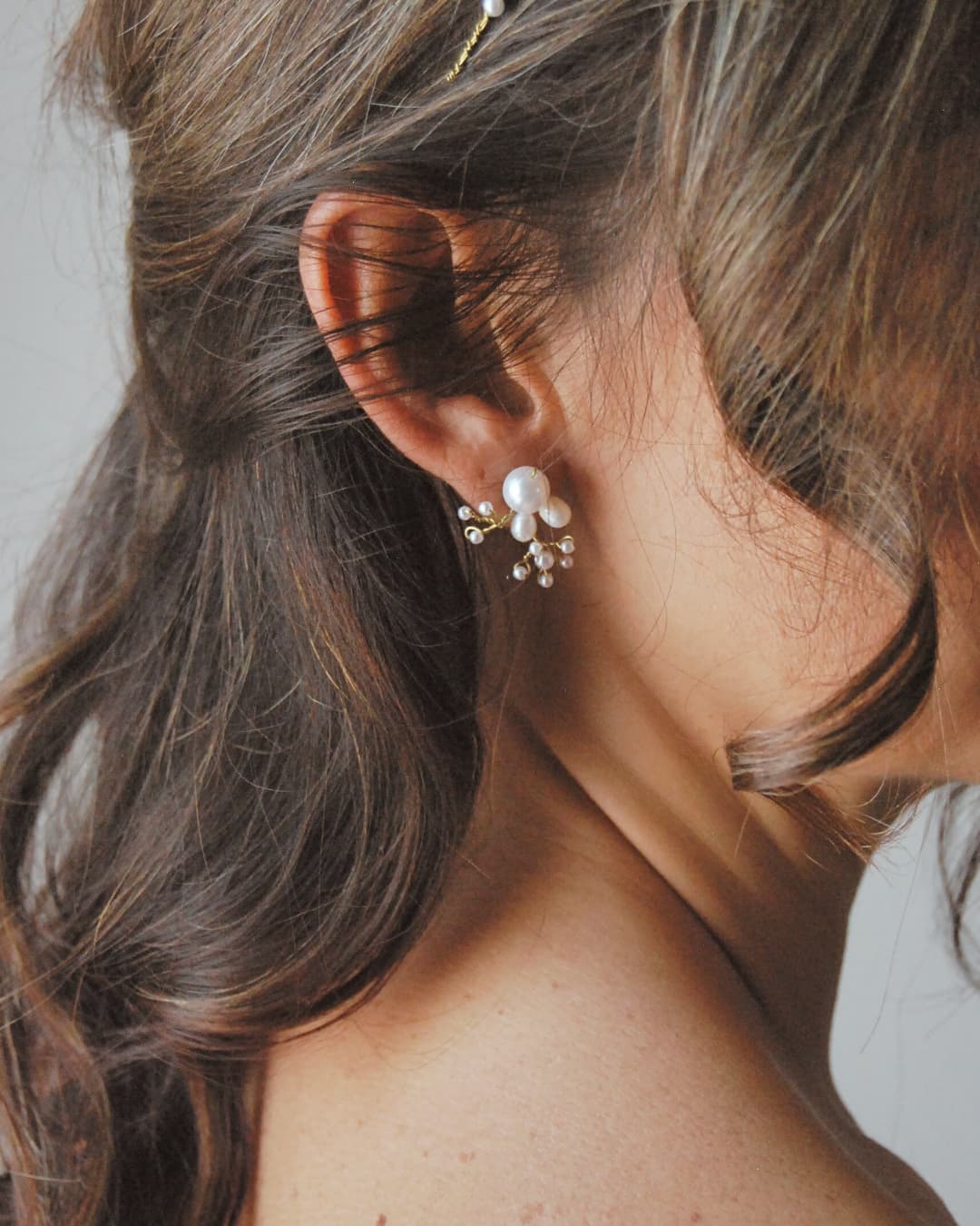 Orecchini artigianali con composizione organica di perle e finitura dorata di alta gamma.