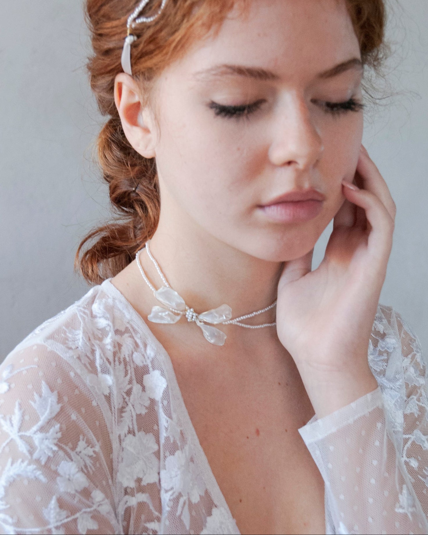 Gioiello da sposa: collana di perline con un fiocco laterale delicato.