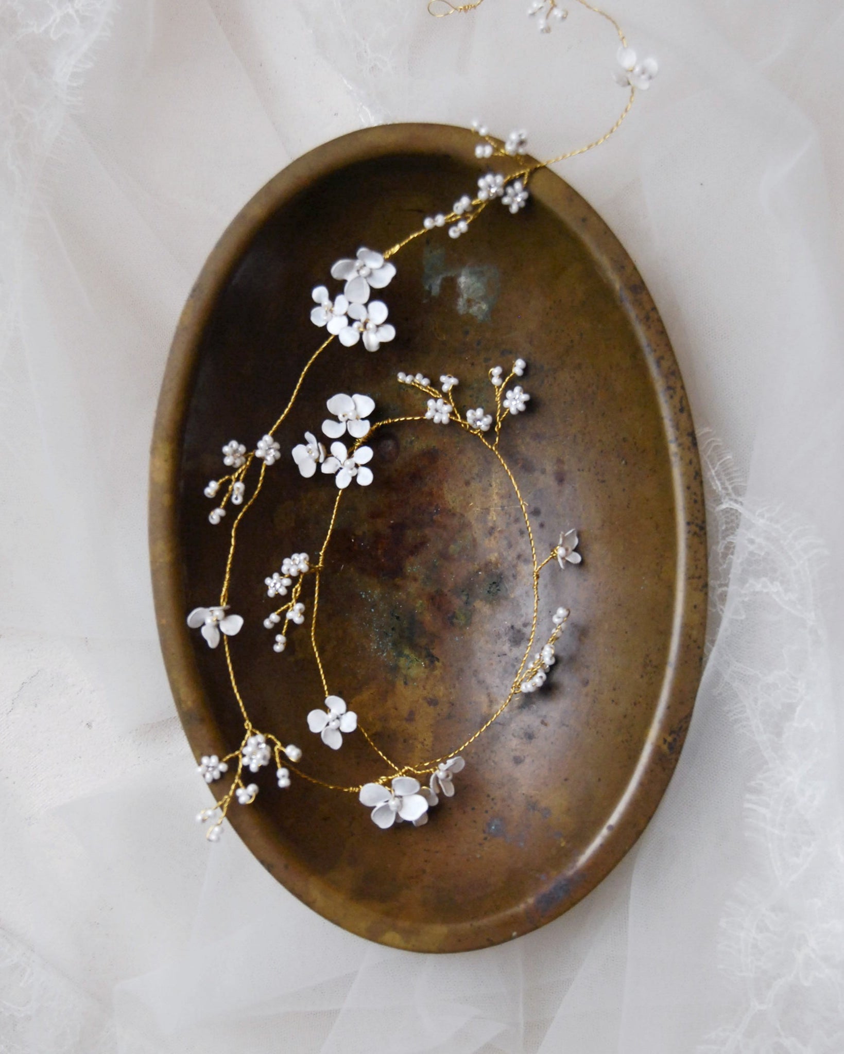 Lungo filo gioiello con fiorellini bianchi per acconciature da sposa romantiche e speciali