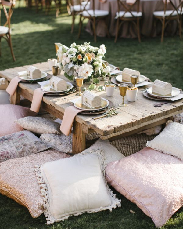 Matrimonio boho-chic e shabby chic: tavolo apparecchiato basso con cuscini in stile naturale e romantico