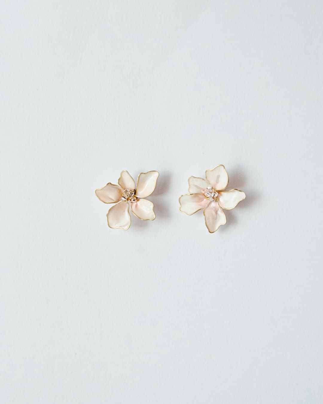Dettaglio dei petali smaltati e sfumati a mano degli orecchini Bloom per un look romantico.