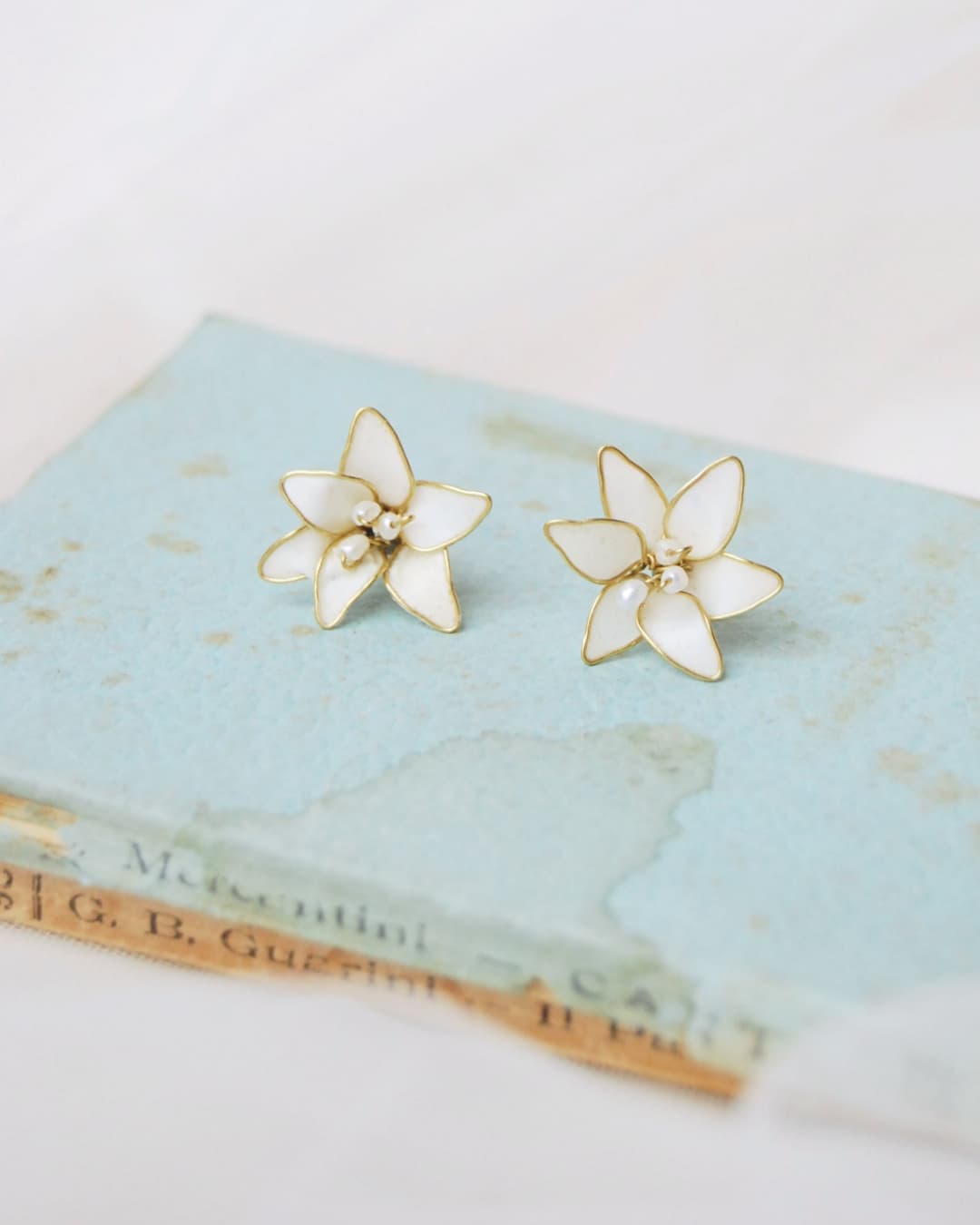 Orecchini a lobo sposa Lilium Elibre con fiori di giglio bianchi modellati a mano.