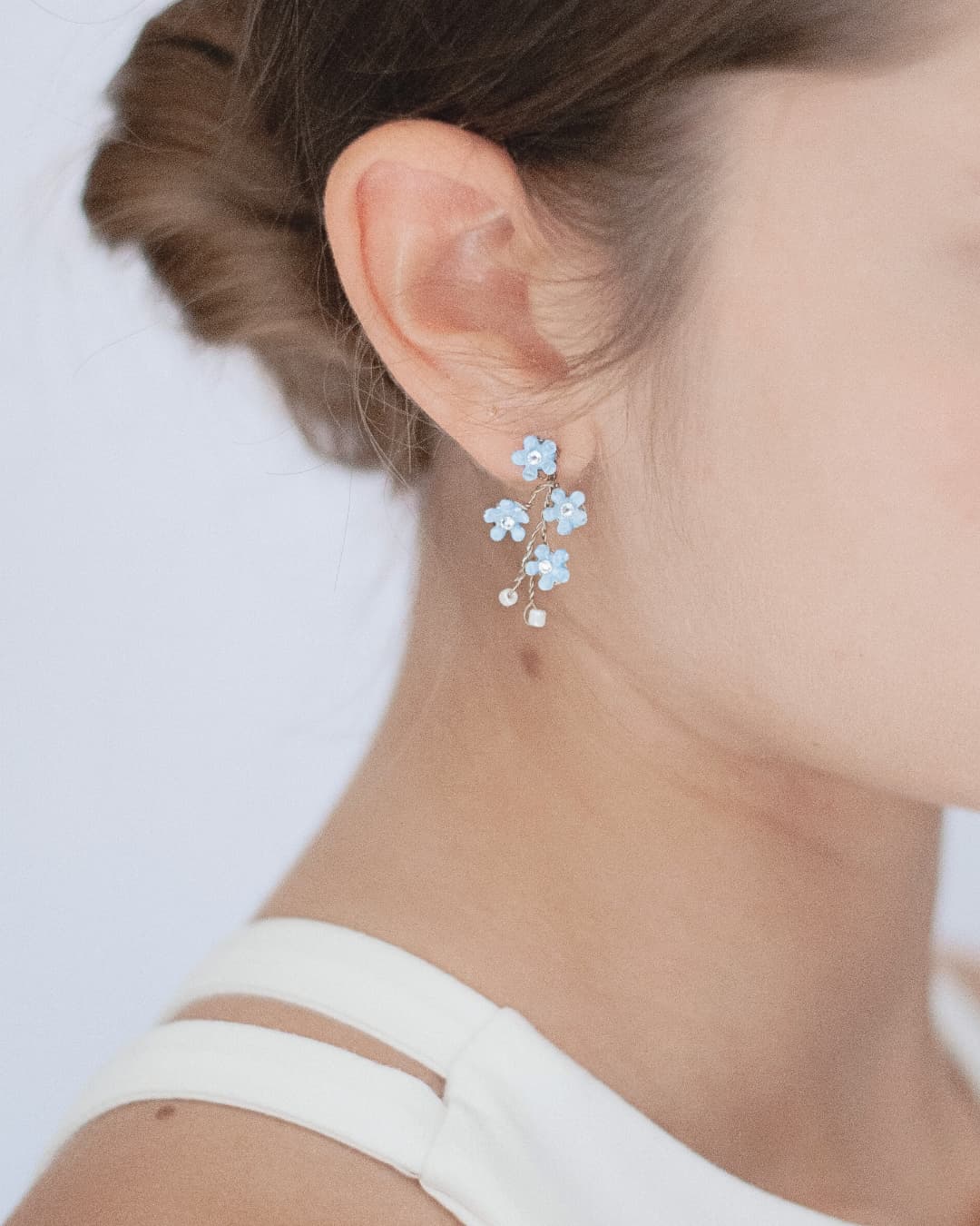 Orecchini artigianali Elibre color azzurro pastello a forma di Non ti Scordar di Me con cristalli per la sposa.