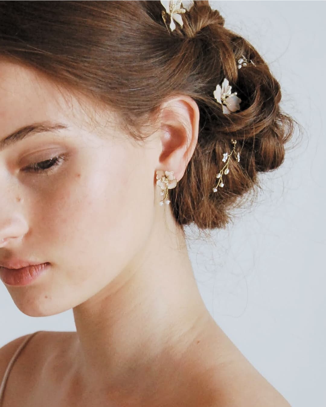 Dettaglio indossato degli orecchini ispirati ai fiori di ciliegio per un bridal styling raffinato.