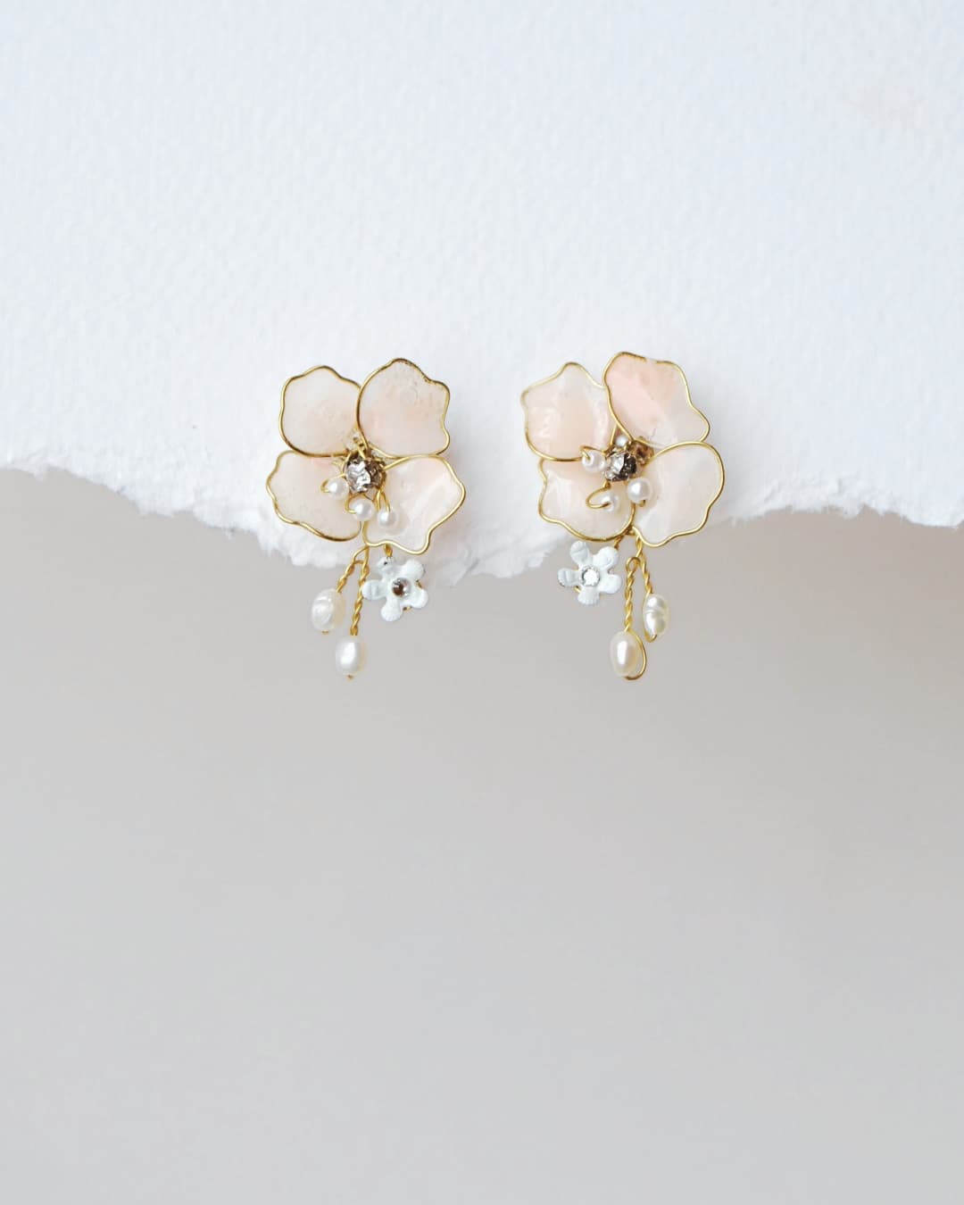 Orecchini Sakura Elibre con fiori rosa cipria e rametti di perline, un accessorio floreale raffinato per la sposa.