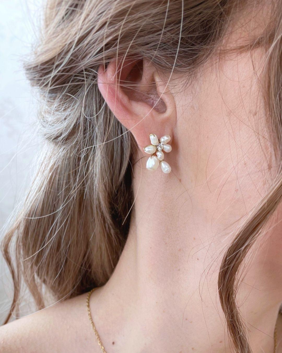 Orecchini a lobo Marguerite indossati da una sposa, fiori di perle e cristalli.