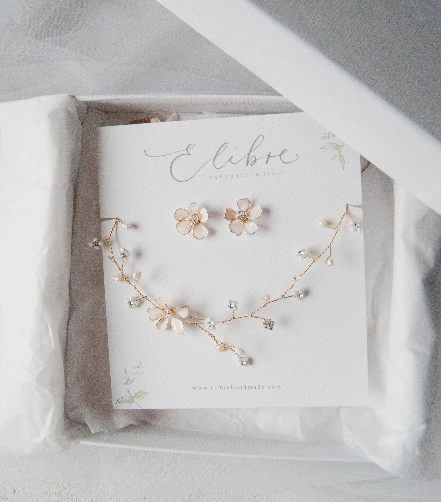 Parure da sposa artigianale composta da collana e orecchini a fiore rosa coordinati, elegante e raffinata.