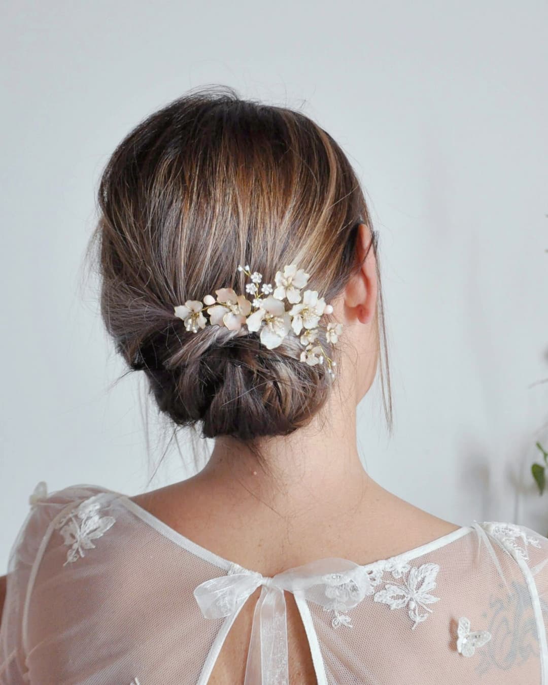 fiori di ciliegio smaltati del pettinino indossato su acconciatura sposa raccolta