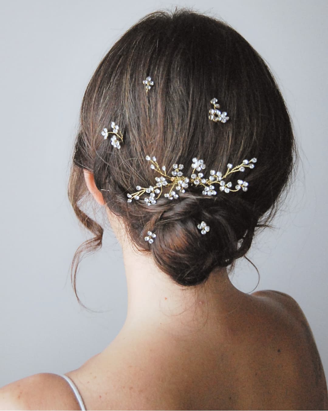 Pettinino abbinato al set di forcine Brillaflora indossato su un raccolto elegante per un'essenza femminile e luminosa.