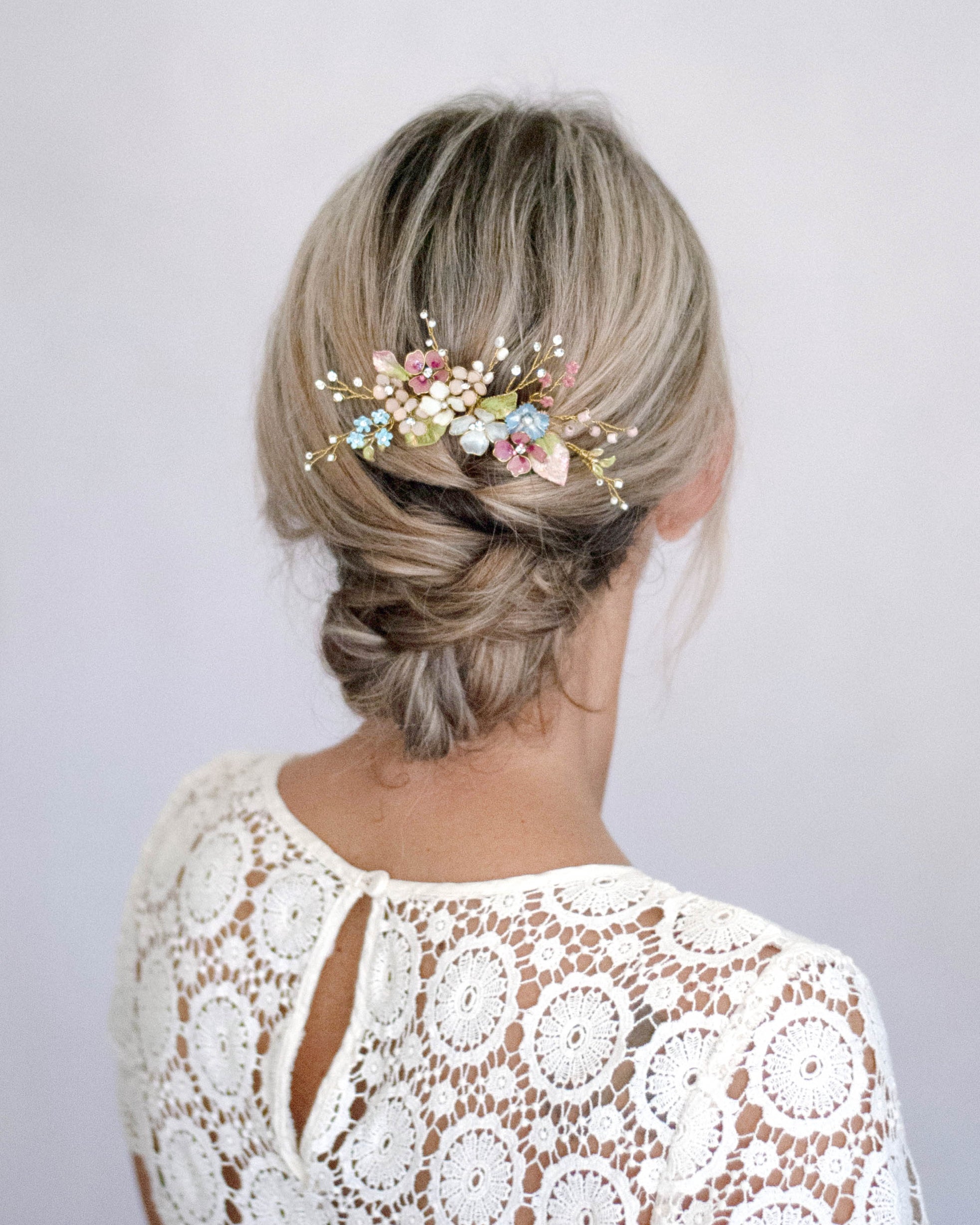 Pettinino sposa stile country chic con fiori di campo, perfetto per cerimonie all’aria aperta.