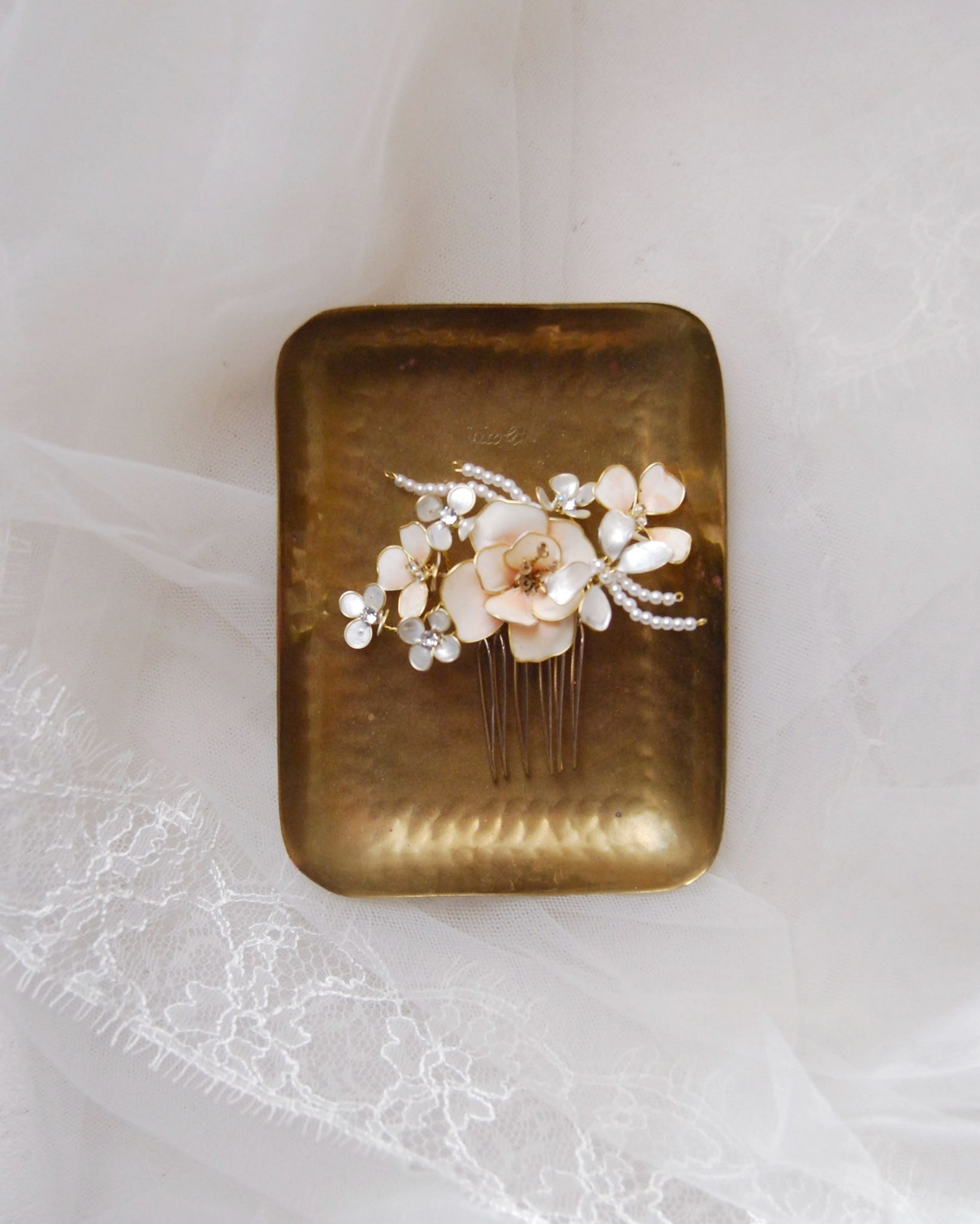 Pettinino rosa decorato con fiori madreperlati, un accessorio elegante per spose romantiche.