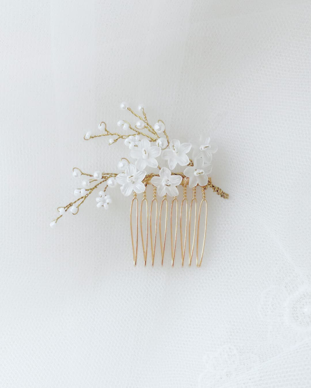 Pettinino sposa Frangipane Mini con fiori satinati artigianali, perle naturali e rami oro.